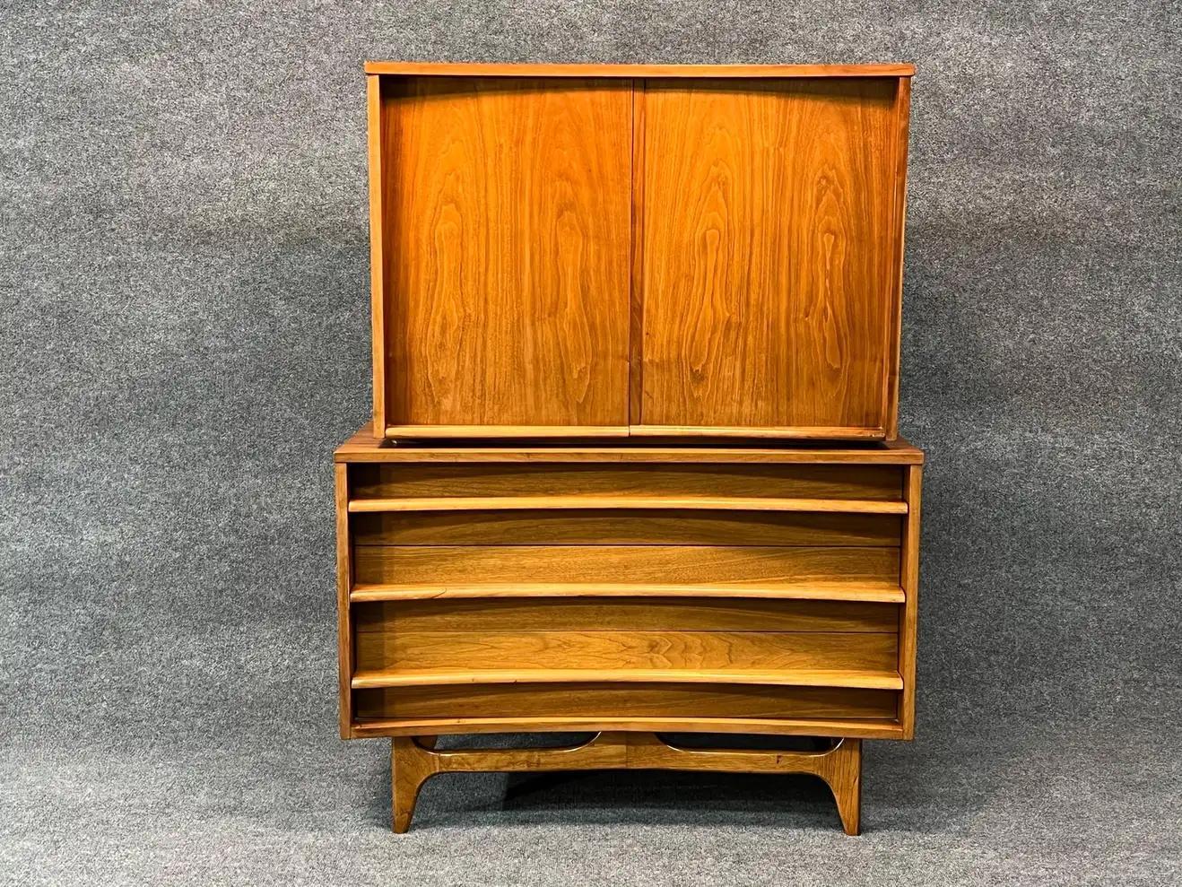 This listing is for a mid-century Young Manufacturing walnut dresser. Featuring a graciously curved front design, nine drawers for storage, and a beautiful walnut finish. An extraordinary design to complete your bedroom as a dresser or living room