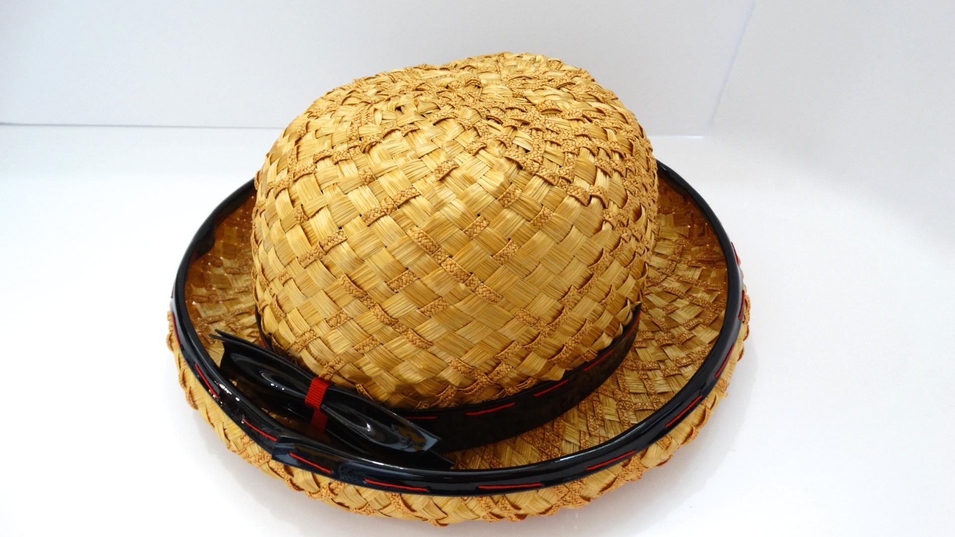 Very early 1960s Yves Saint Laurent bowler hat! Gold yellow straw, intricately lattice woven and trimmed with black patent piping. Piping sewn overtop with contrasting red thread in long, oversized stitches. Features a matching black patent bow on