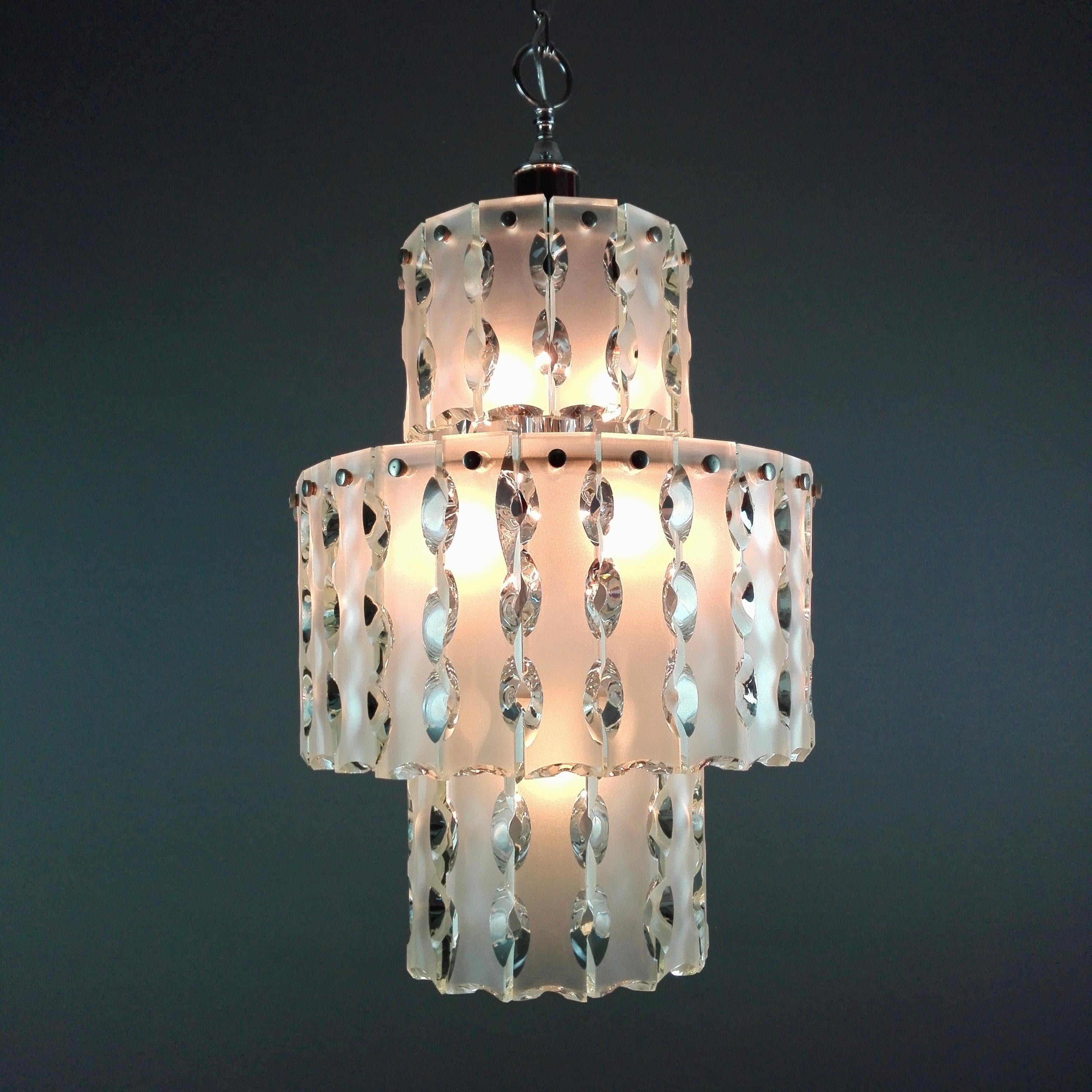 Wonderful 60s Italian ten-light pendant lamp. The light is composed of a circular chrome structure to which are attached on three levels of different diameters 50 elements in ground and chiseled transparent glass, with etched front surface. 
There