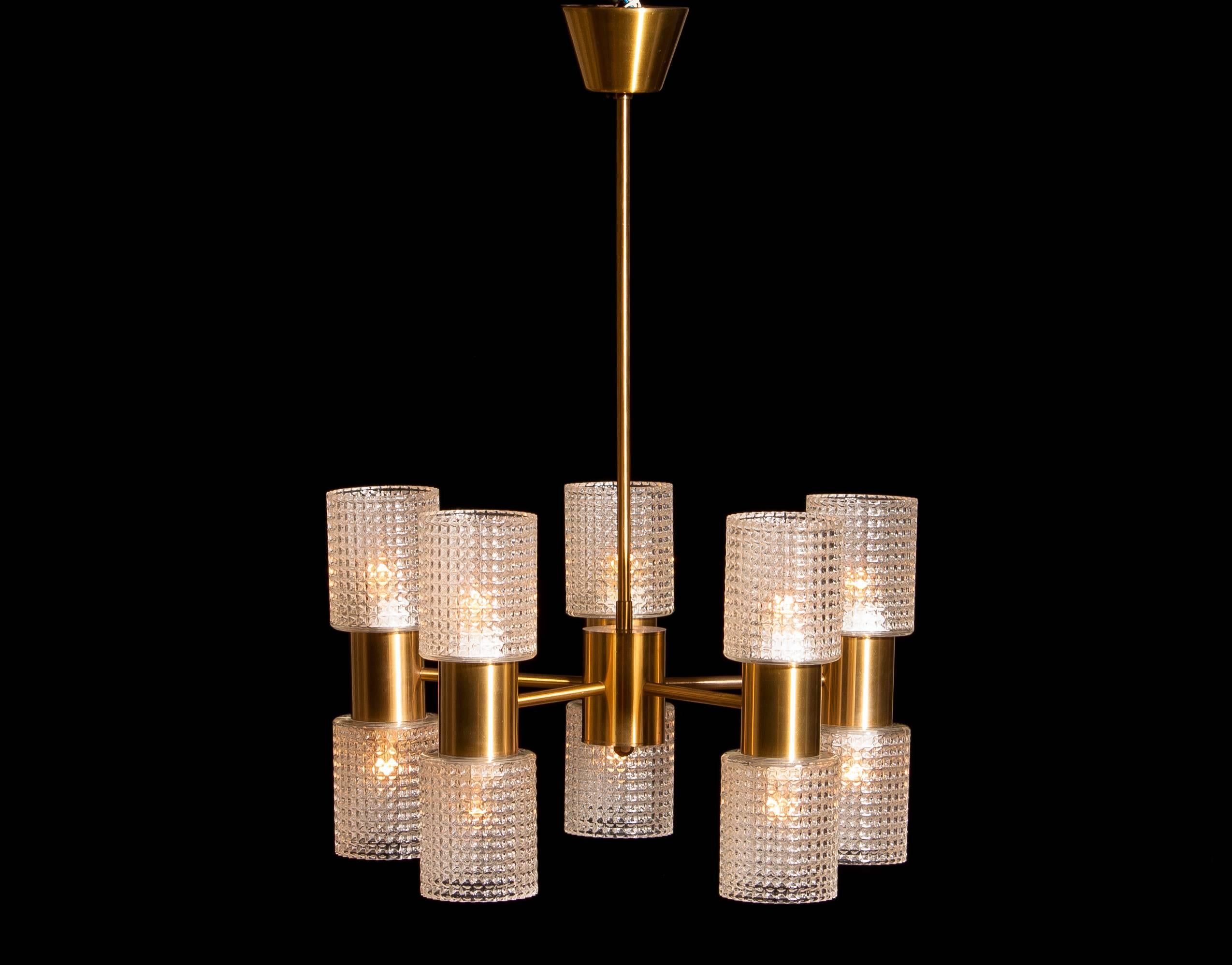 Beautiful chandelier designed by Carl Fagerlund for Orrefors, Sweden.
This lamp is made of brass and glass.
It consists of five arms with on each arm two glass shades.
The upper and the lower row bulbs can be switch on separately of each