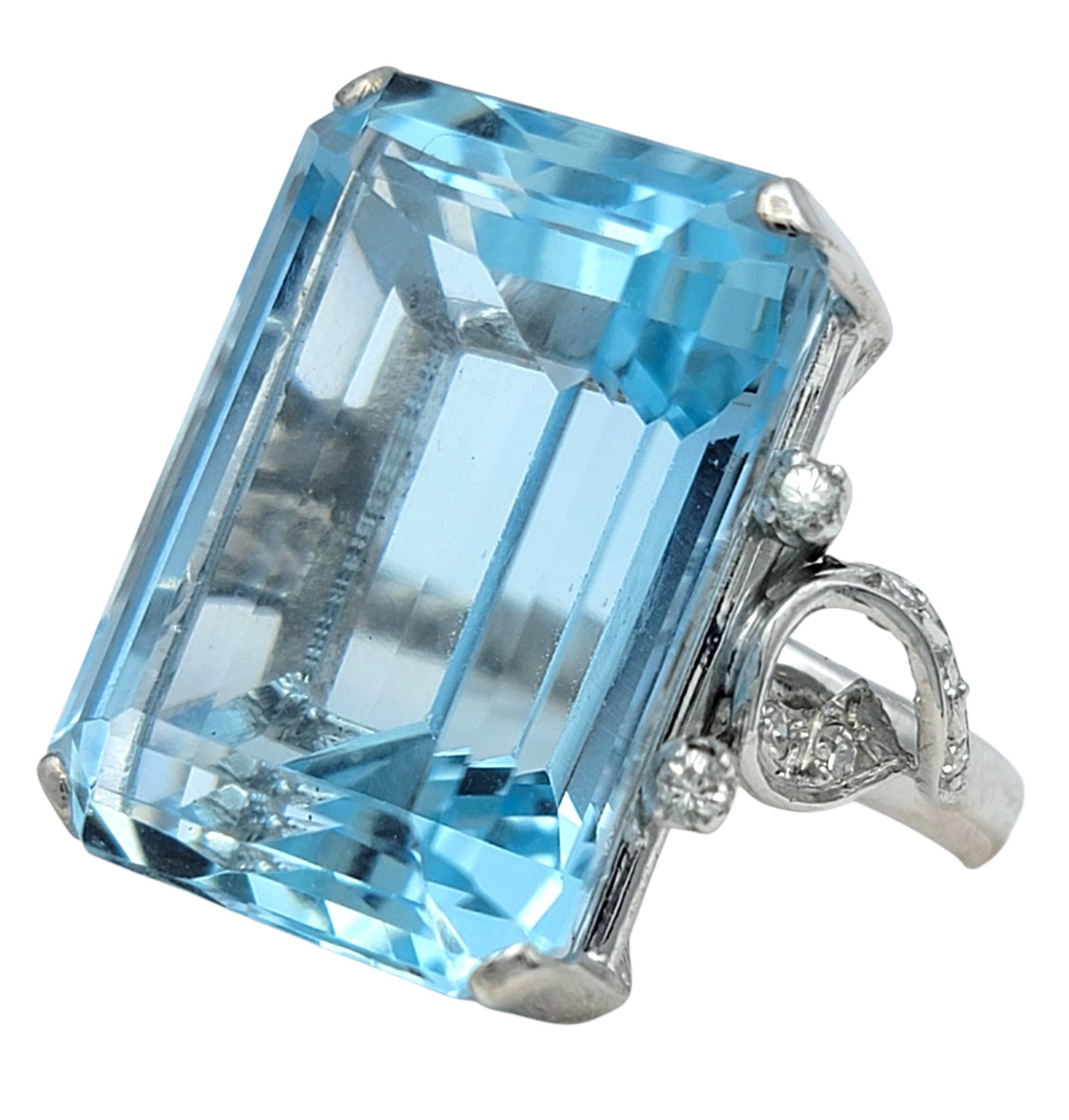 This striking ring features a bold, icy-blue aquamarine that immediately captures attention with its crisp, glassy clarity and elongated emerald-cut shape. Its polished facets create a cool, luminous glow, giving the stone a pristine, almost liquid