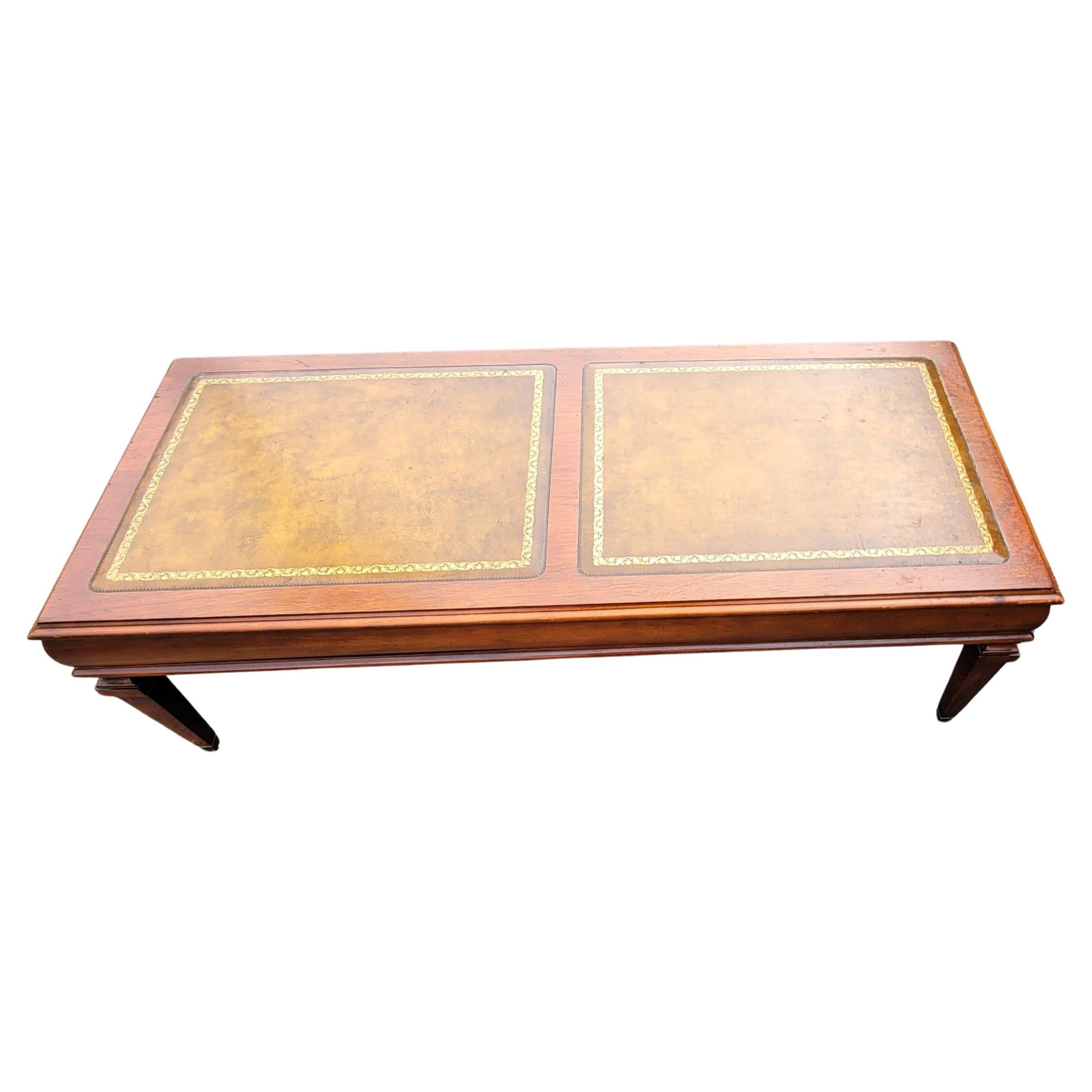 1961 Mahogany and Stenciled tooled leather dual paneled top cocktail table in good vintage condition. 
Measures 48