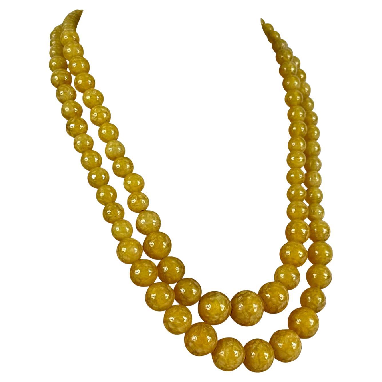 Ich präsentiere eine fabelhafte honigfarbene Halskette von Christian Dior. Erhöhen Sie Ihren Stil mit der zeitlosen Schönheit dieser 1962 Christian Dior Honig abgestuften Perlen-Harz-Doppelkette. Dieses exquisite Stück verkörpert die Essenz des