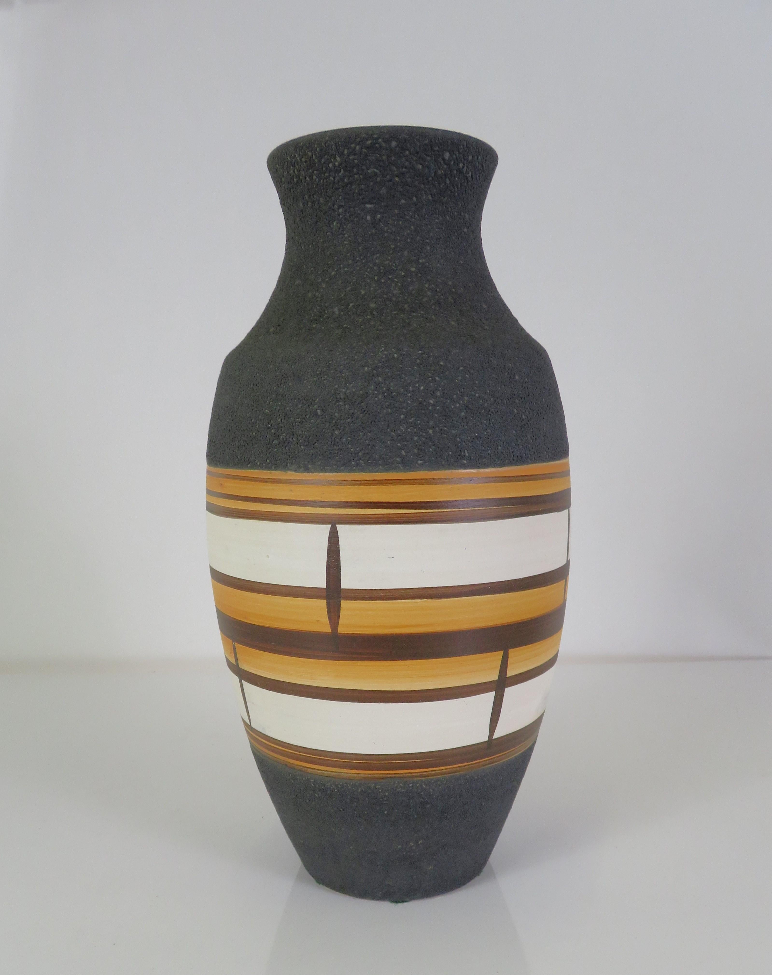 Tactile Modern Lava glaze vase from 1962 by German Bay Keramik. With its more traditional vase shape, a textured charcoal Lava glaze was used in the upper and lower portions of the vase with its center decorated with bands of yellow, brown and