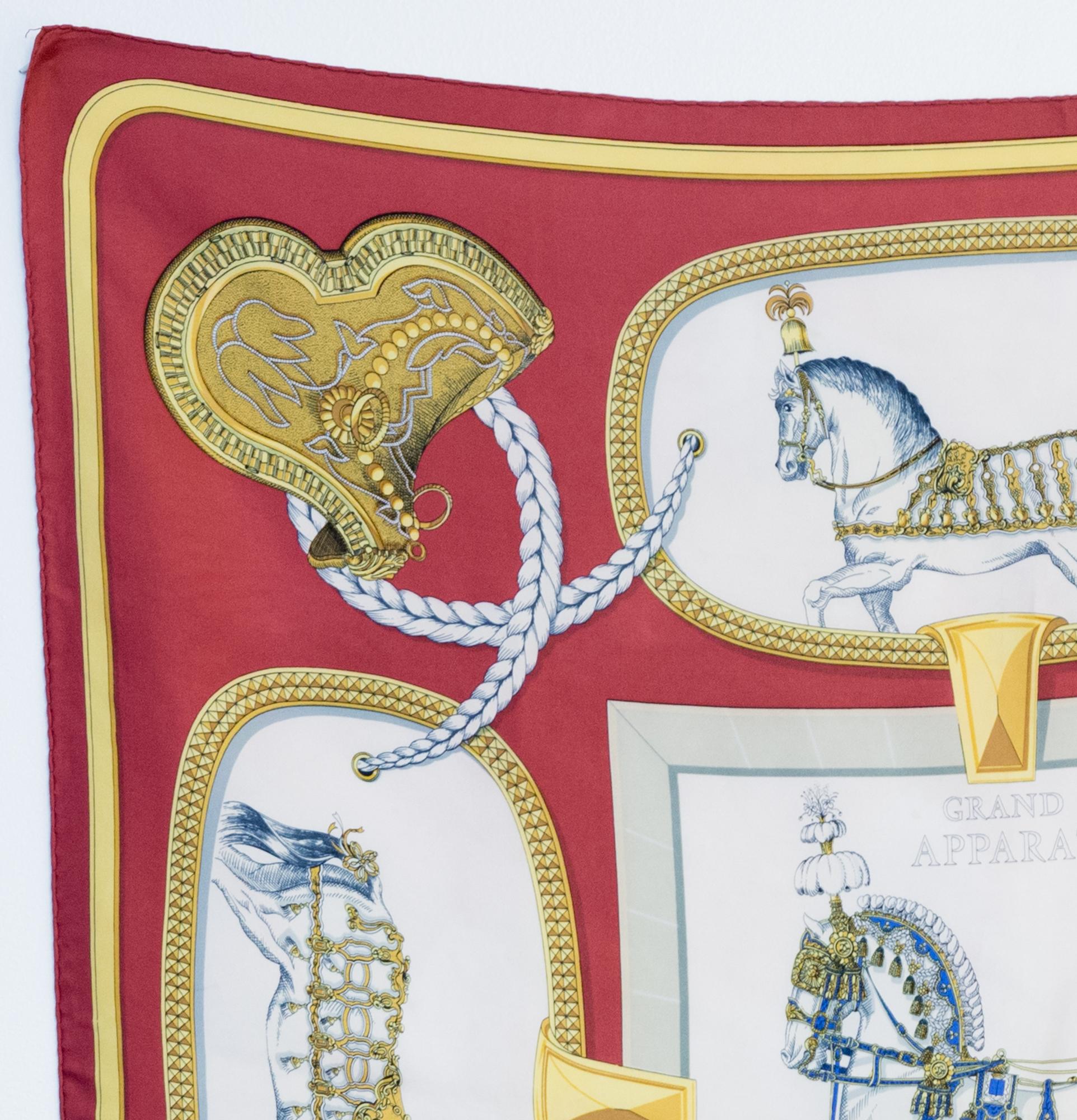 1962 Hermes silk scarf Grand Apparat by Jacques Eudel featuring a dark red border, a horse scene and a top signature.
In good vintage condition. (some discolourations on the ground due to his age) Made in France.
First edition 1962
35,4in. (90cm)  X