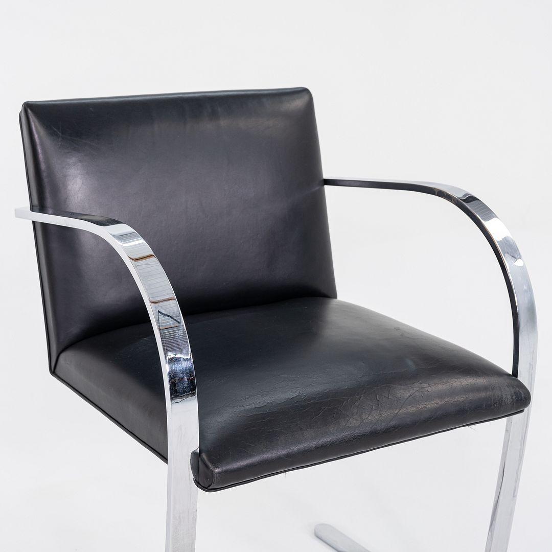 This is a Brno Armchair, model MR50, initially designed by Ludwig Mies van der Rohe and Lilly Reich in 1929. This particular example was produced by Knoll in 1963. The design features a flat, polished stainless-steel frame, utilized throughout the
