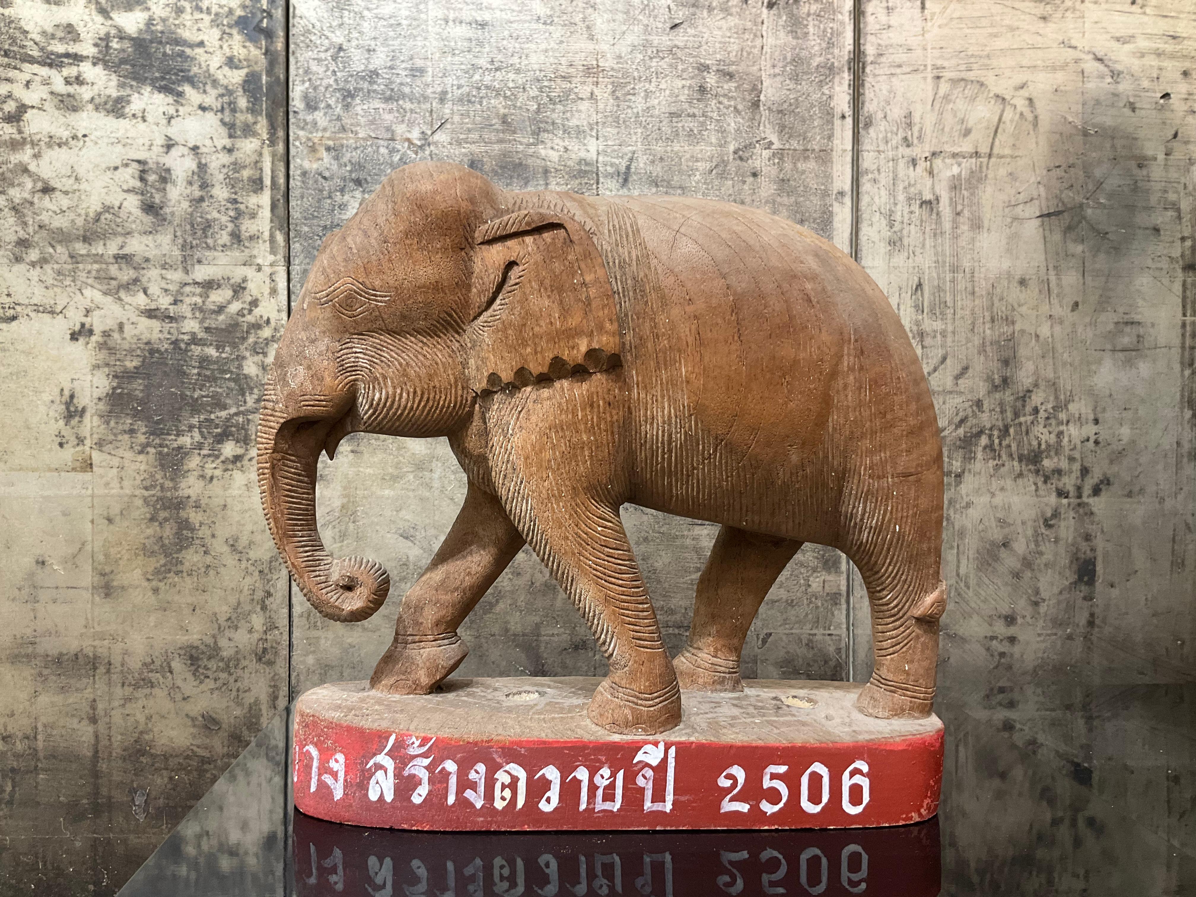 Figure d'éléphant en bois de teck
Chiang Mai, Thaïlande
Daté : Il y a 62 ans (C.I.C.)
MATERIAL : Bois de teck

Cette figure d'éléphant finement sculptée, en teck massif et portant une inscription avec une date, a été offerte comme cadeau votif à un