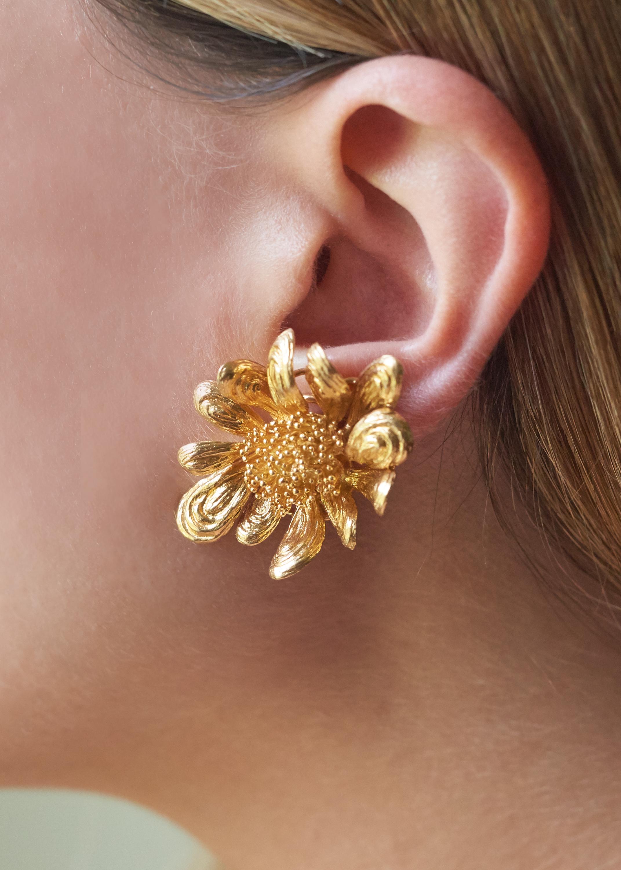 A pair of 18 karat gold floral ear clips, by Chaumet, 1964. Stamped 750, with French hallmarks. Stamped with Chaumet maker's mark. 

The perfect pair of flower earrings that will last a lifetime and will add a touch of glamour to your style. The