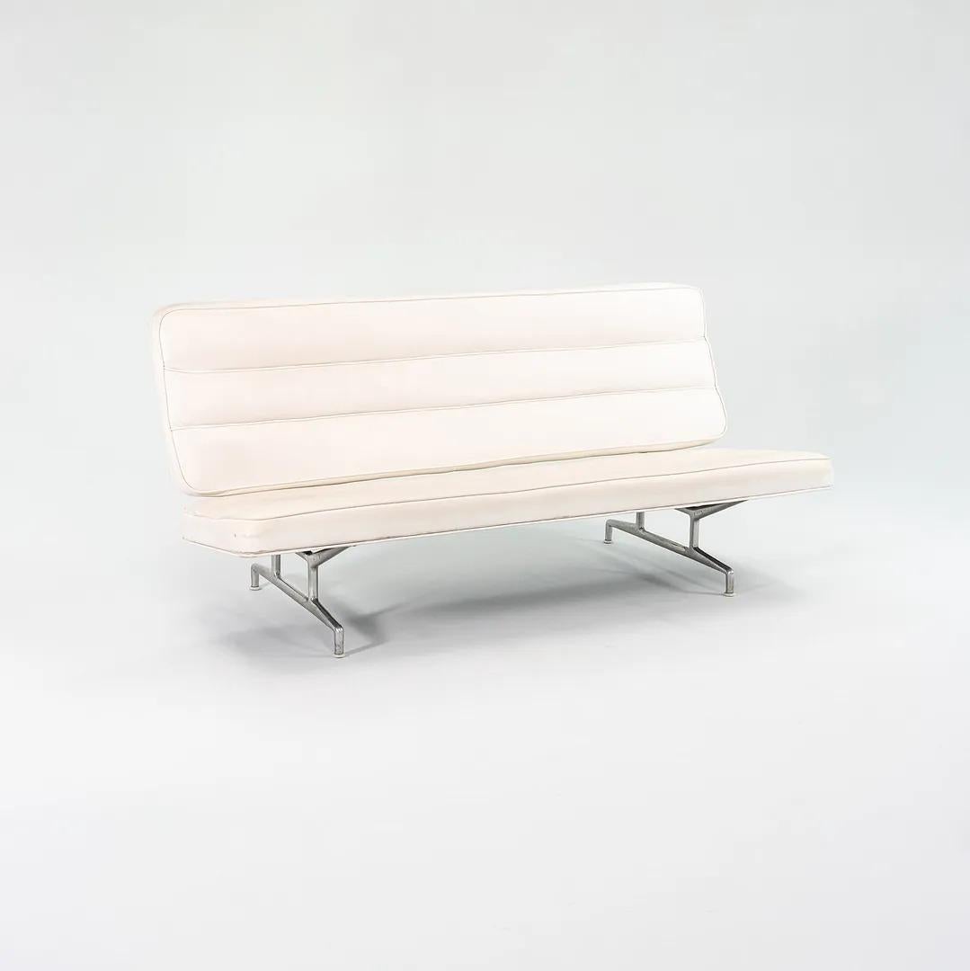 This is a 3473 sofa, originally designed by Charles and Ray Eames for Herman Miller in 1964. It's constructed from aluminum, iron, and plywood. It may be the original white naugahyde upholstery, though was more likely reupholstered later in its