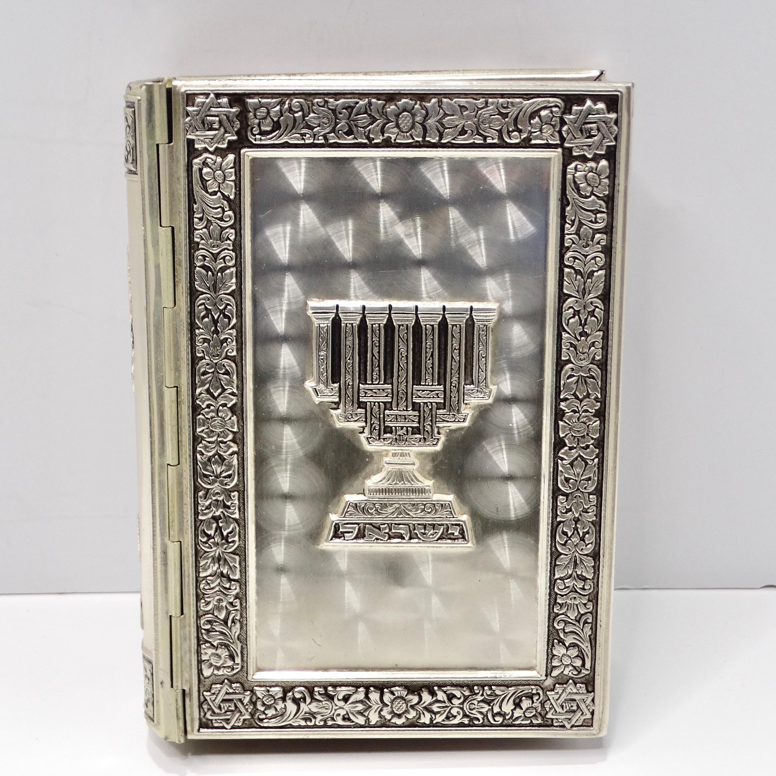 Introducing the exquisite 1964 Gem Encrusted Jewish Torah,a stunning testament to craftsmanship and devotion. This silver-plated Hebrew prayer book is adorned with intricate engravings that depict a rich tapestry of Jewish symbolism and