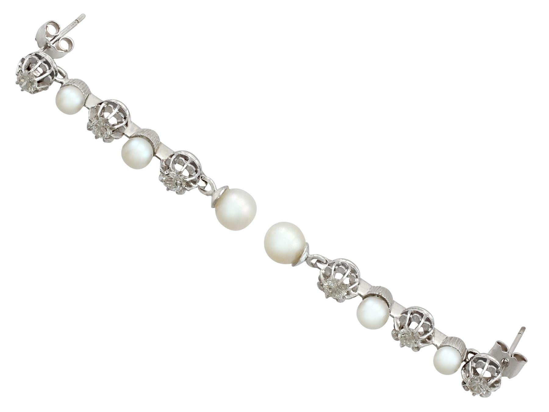 An impressive pair of vintage cultured pearl and 1.09 carat diamond, 9 karat white gold drop earrings; part of our diverse pearl jewelry and estate jewelry collections.

These fine and impressive vintage earrings have been crafted in 9k white