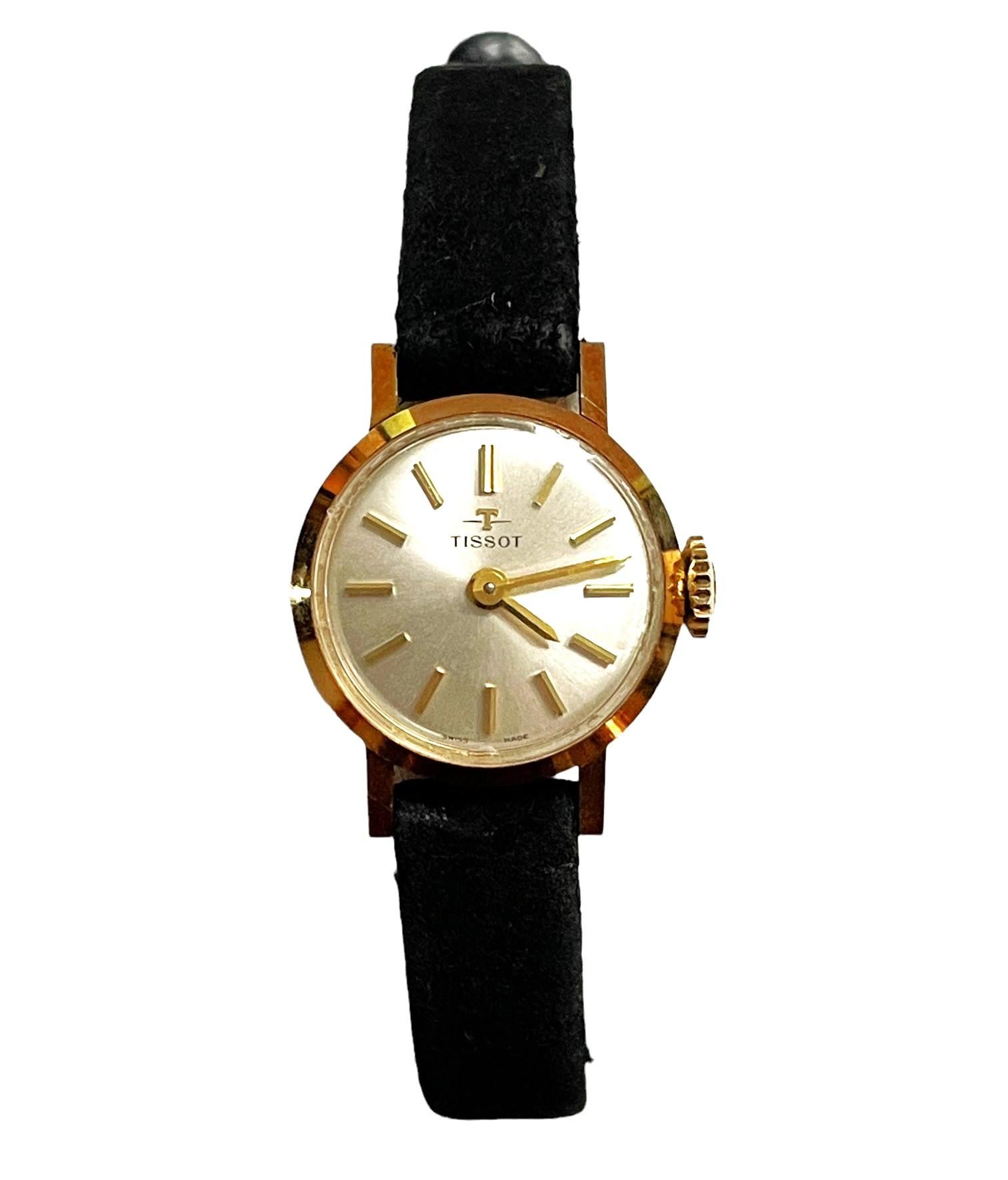 This is a Woman's 18k Yellow Gold Swiss 17 Jewel Manual Watch.  Watch has marks and scratches on back side from wear.  Overall the crystal is fully clear and watch winds and runs as it should.   Features 18k Yellow Gold Case and a black suede band