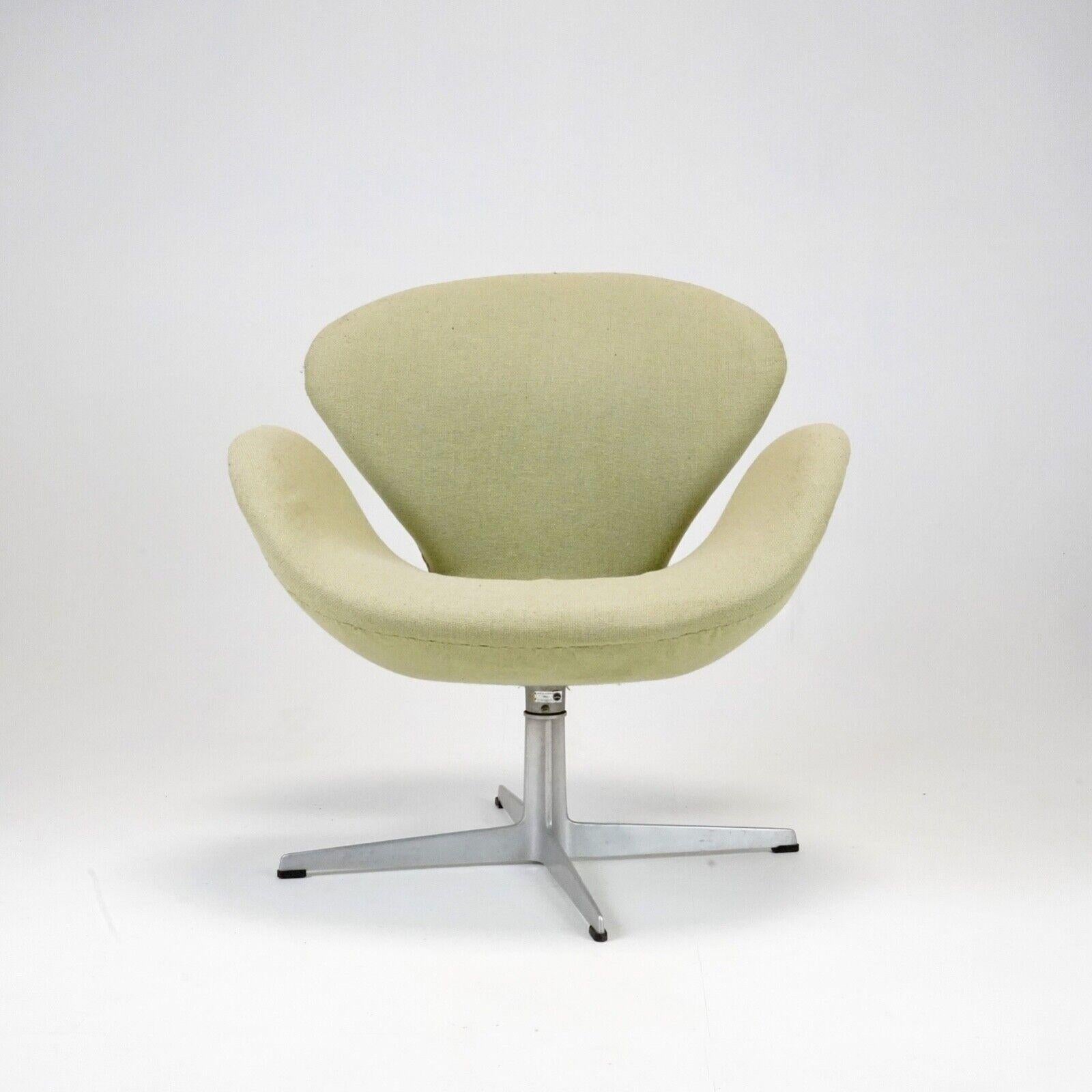 An early edition, Arne Jacobsen Swan chair produced by Fritz Hansen.
The chair has its original label that dates to 1966.
Original green natural fibre fabric that has ever so slightly faded and looks great for it. 
Spins well and in good