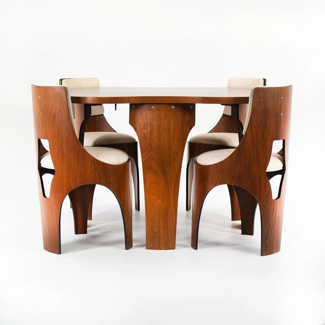 This is a handsome ‘Cylindra’ walnut dining set, designed by Henry P. Glass and produced by the Richbilt Manufacturing Company in 1966. The set includes a clover-shaped dining table with four chairs, and has one matching leaf. Glass was one of the