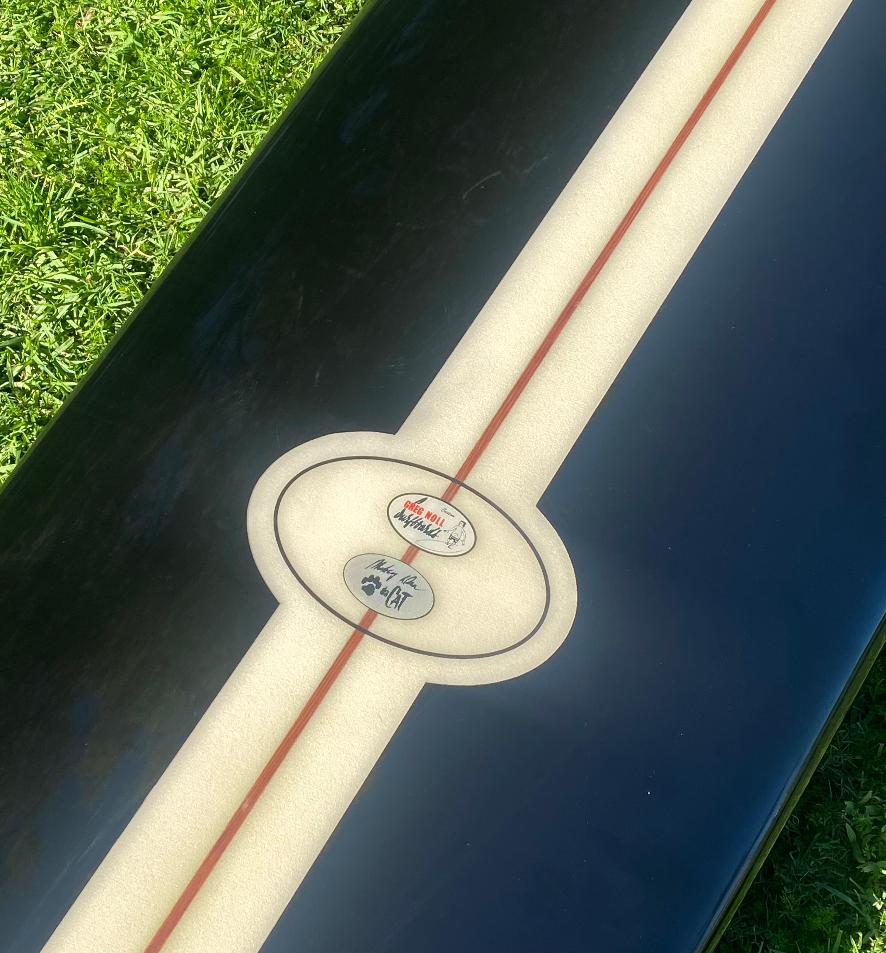 1966 Vintage Greg Noll Miki Dora Da Cat longboard. Features the most desired black pigment variation which Miki Dora was known to ride himself. A highly coveted 1st generation Greg Noll Miki Dora Da Cat, known by the pronounced step deck and