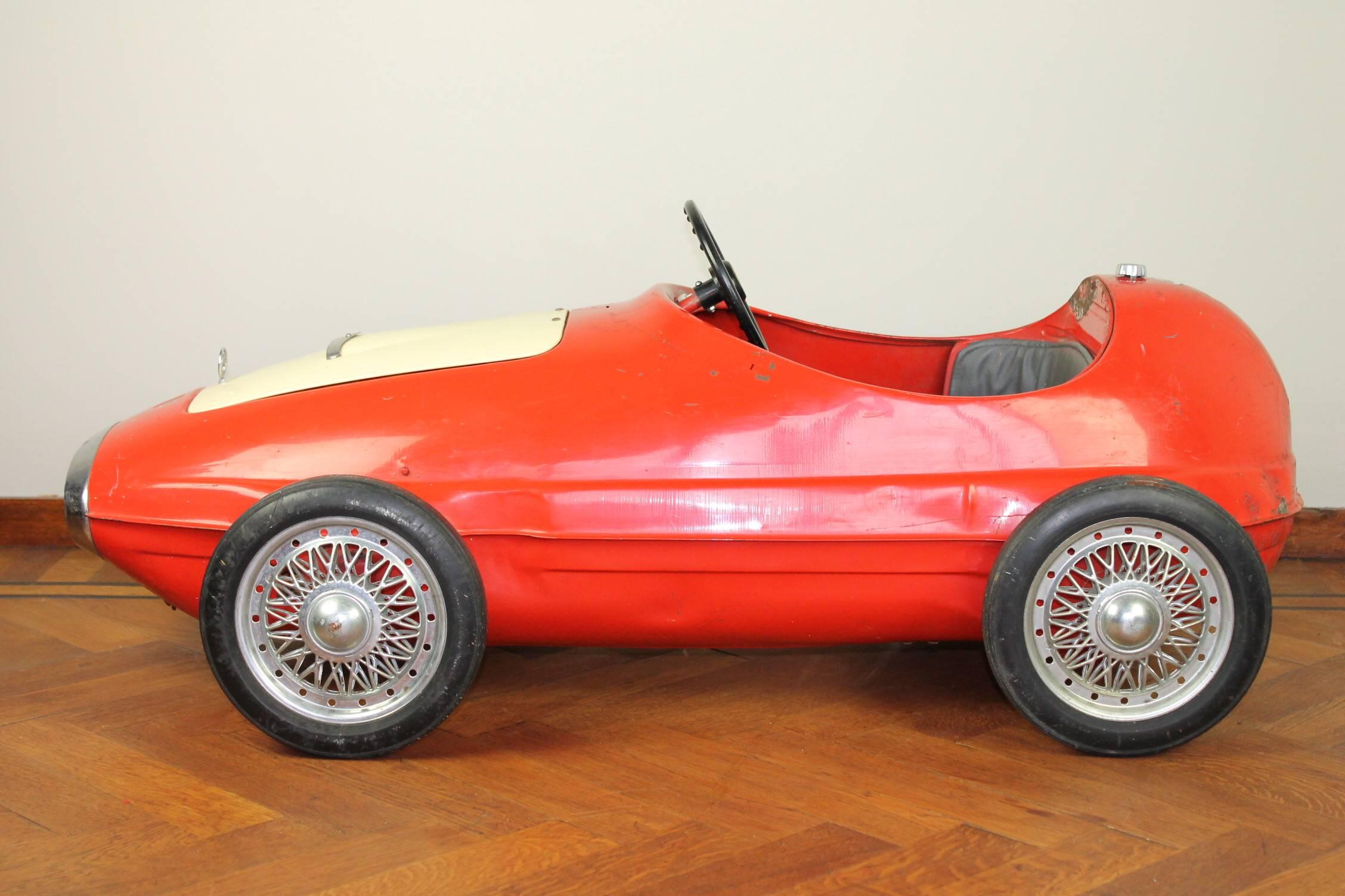 Sporty metal racer pedal car made by Giordani Bologna Italy from 1966.
Type: Auto Sprint M-MR / Ferrari - Maserati - Sportscar - Racecar.
This auto sprint line acquired a curious detail namely the mock engine mounted under a open able