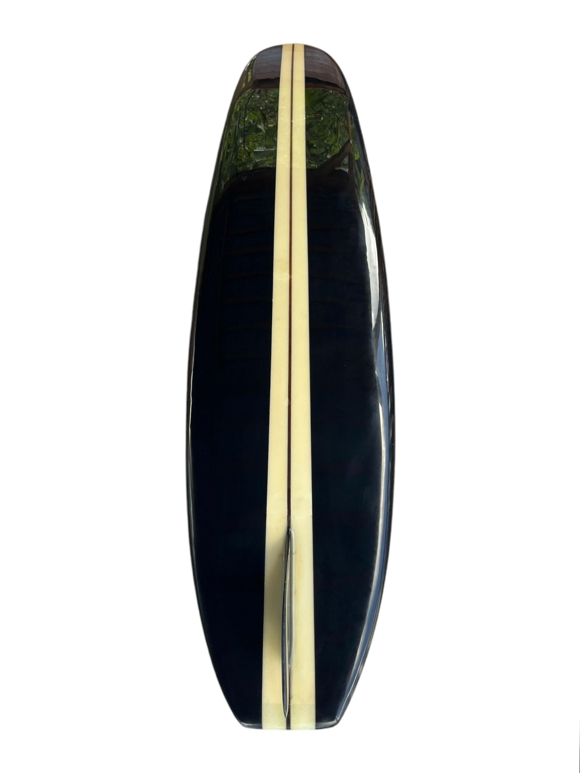 1966 vintage Greg Noll Miki Dora Da Cat longboard. Features the legendary black cat color scheme Miki Dora was known to ride. A remarkable example of the highly prized 1st generation “Da Cat”, famous for it’s step-deck and signature glass-on Da Cat
