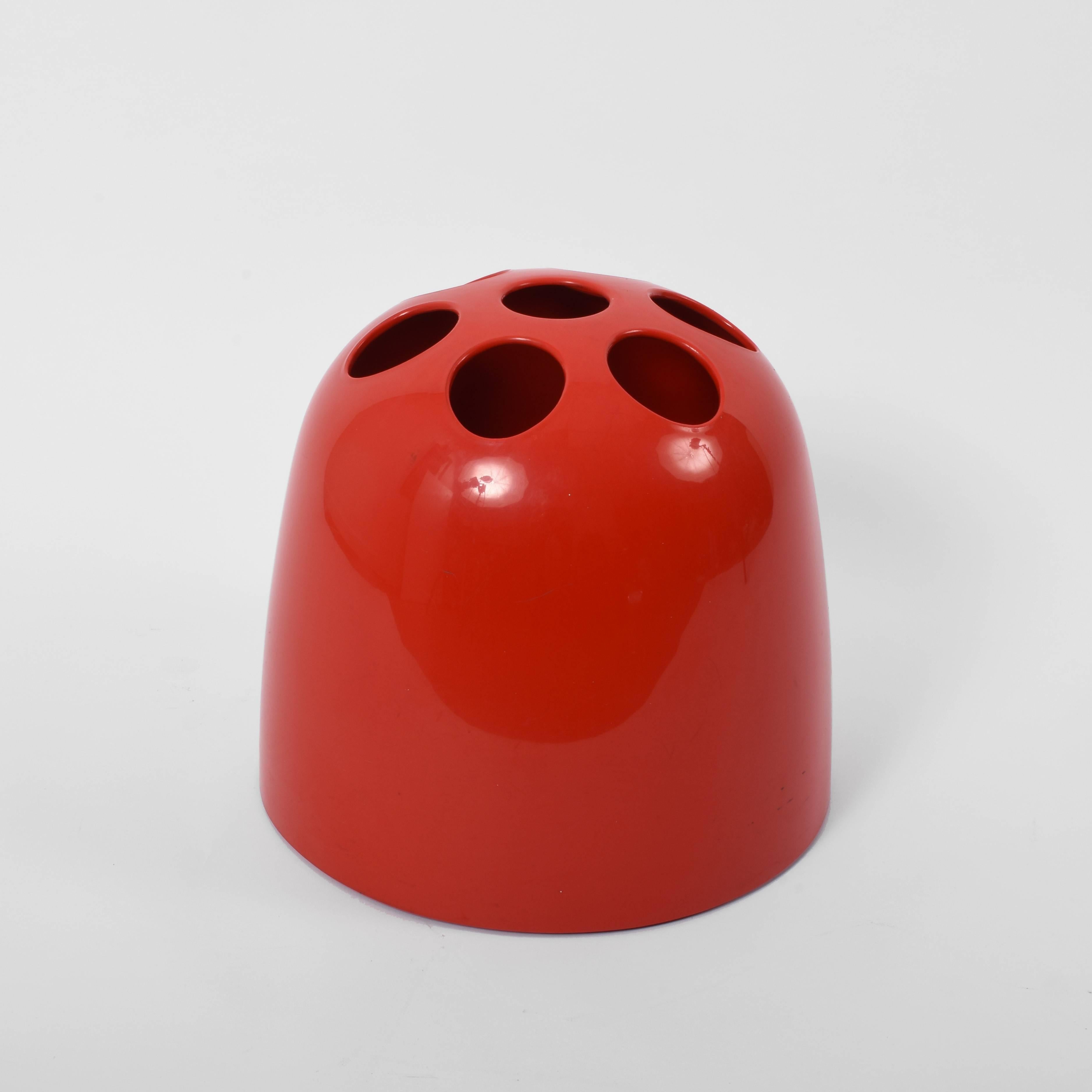 This umbrella stand, model Dedalo, was designed by Emma Gismondi Schweinberger and manufactured by Artemide in 1966. It is made from ABS plastic in red. The original object was produced in three different sizes: small pencil holders (Dedalino),