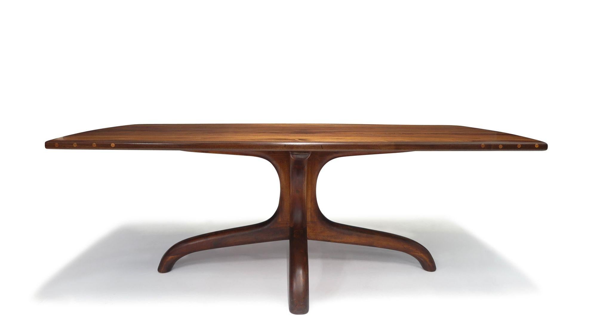 Arthur Espenet Carpenter Black Walnut Dining Table
This exquisite dining table is characterized by its long rectangular top with gently curved sides, accentuated by exposed joinery on the sides, Supported by a sculptural pedestal base, this table is