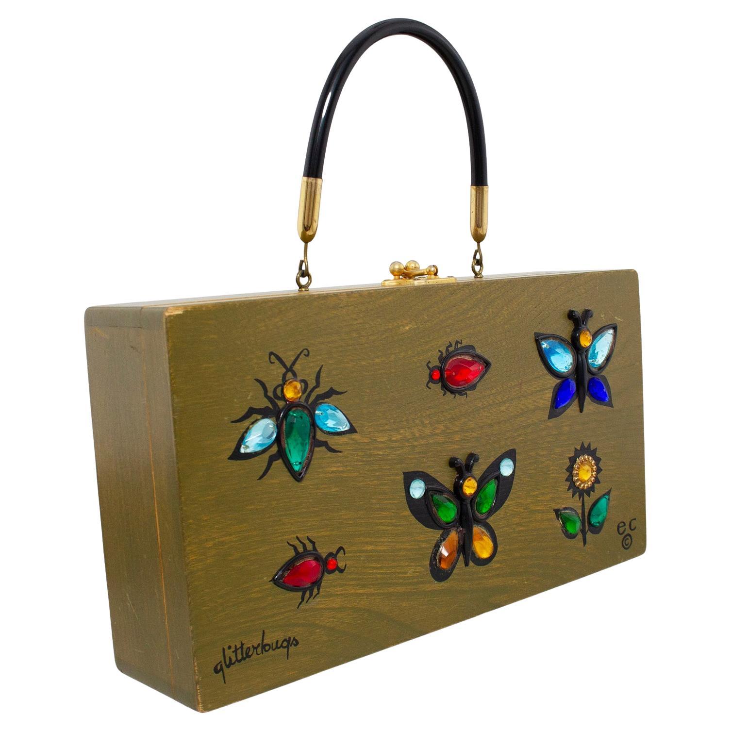 Original hand decorated Enid Collins 1967 'Glitterbugs' box bag. Olive green stained wood exterior with black hard handle and brass fittings. Circular mirror under the lid, interior clean and fresh. Normal signs of wear to the corners. Overall