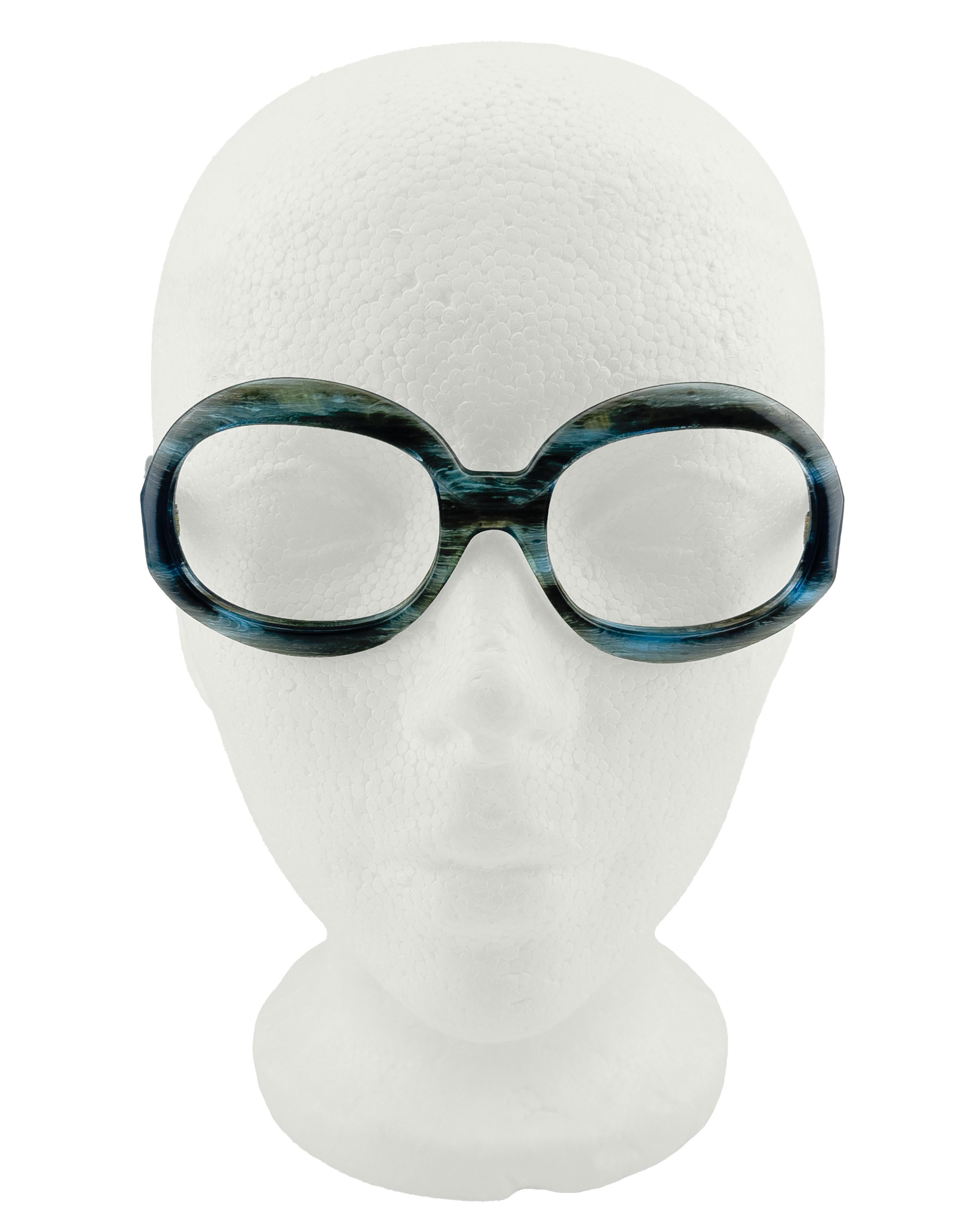 Entra in un'atmosfera nostalgica con queste montature quadrate vintage in un'ondata di blu e grigio. Il design in acetato marmorizzato dona un effetto fluido, quasi tempestoso. Con una silhouette robusta e bordi dolcemente curvi, questa coppia fonde