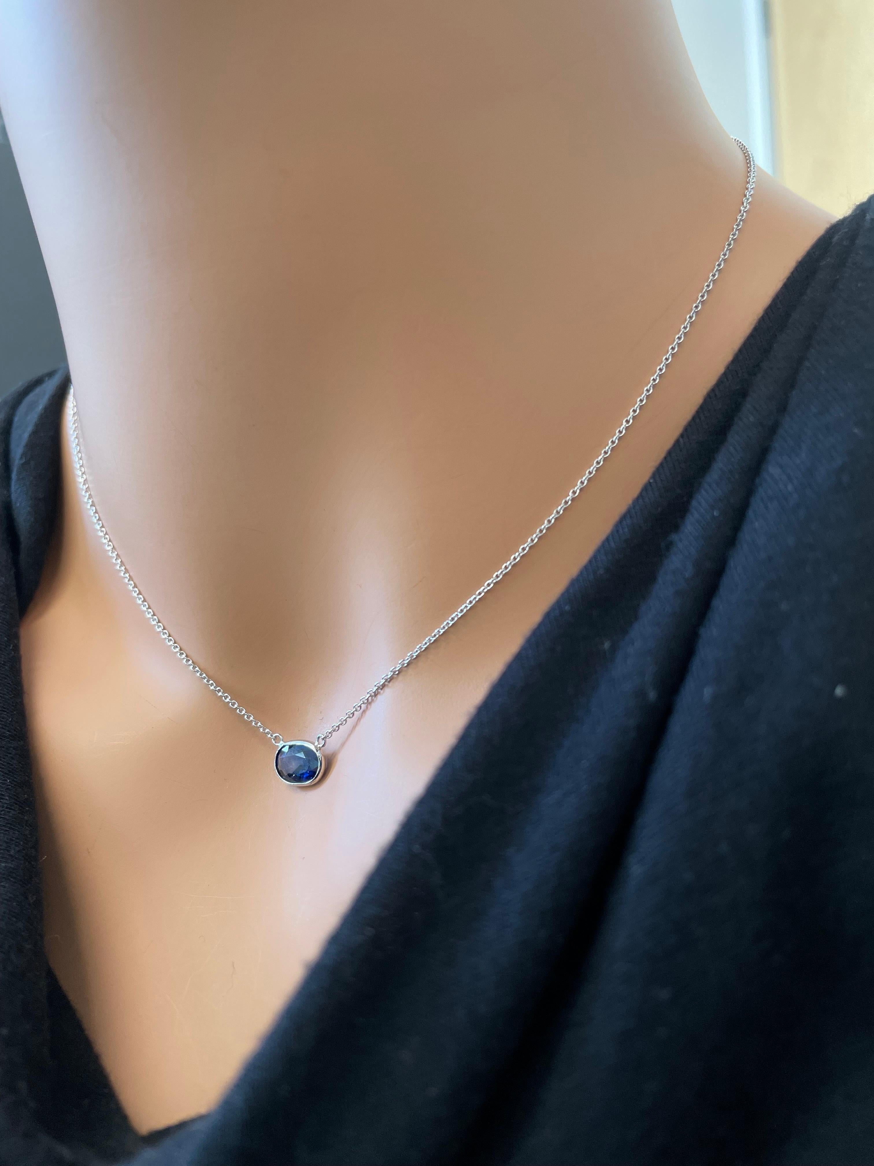 This necklace features an oval-cut blue sapphire with a weight of 1.97 carats, set in 14k white gold (WG). Blue sapphires are renowned for their deep, rich blue color, and the oval cut is a classic choice for gemstones, providing a timeless and