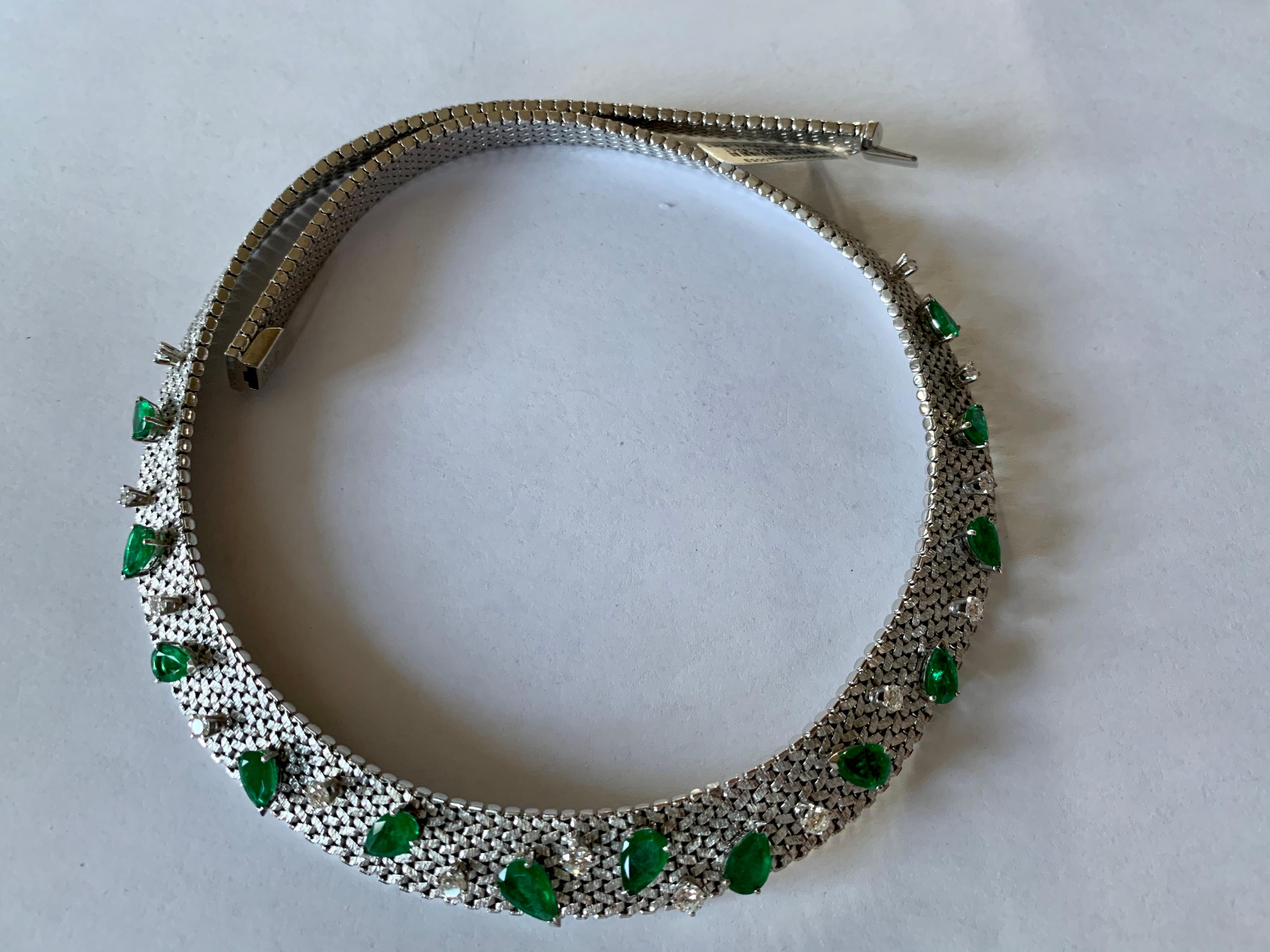 Diese Diamant- und Smaragd-Halskette im Vintage-Stil aus den 1970er Jahren hat eine flache Kette und ist mit 14 Diamanten im Brillantschliff mit einem Gewicht von 1,30 ct, G, vs und 13 birnenförmigen Smaragden mit insgesamt 6,82 ct besetzt. 
Diese