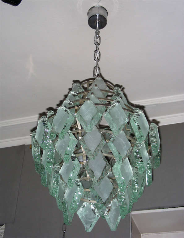 1970-1980 Italian chandelier. 
Chromed metal structure and handcut and sanded glass drops. 
Seven lights.