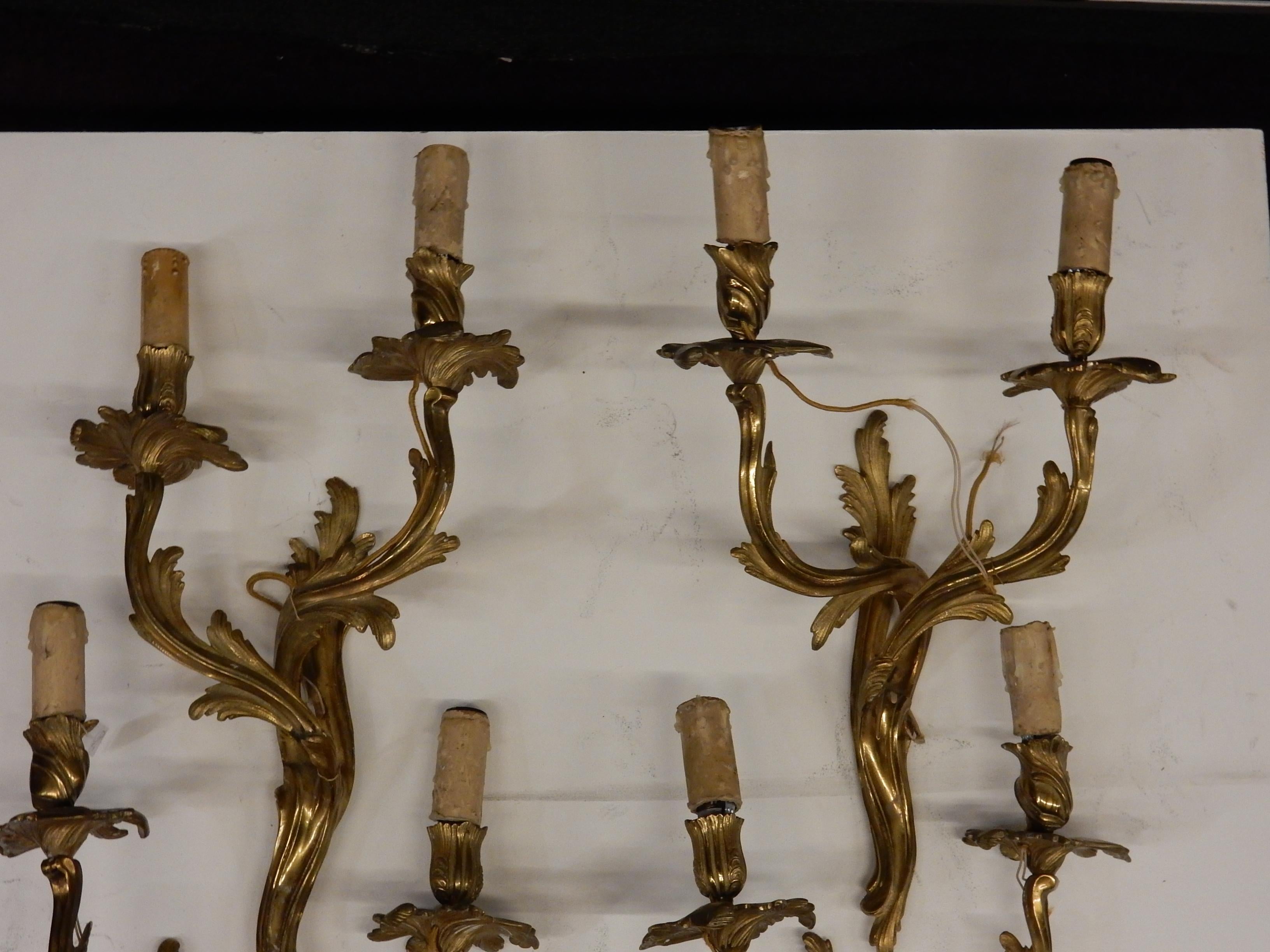 Series of 2 pairs of gilt bronze wall sconces, Louis 15 style, 2 screw bulbs per sconce, label sticker on the back Maison Baguès, 1970-1980. Measures: Height 49 cm, width 33 cm, depth 16 cm.