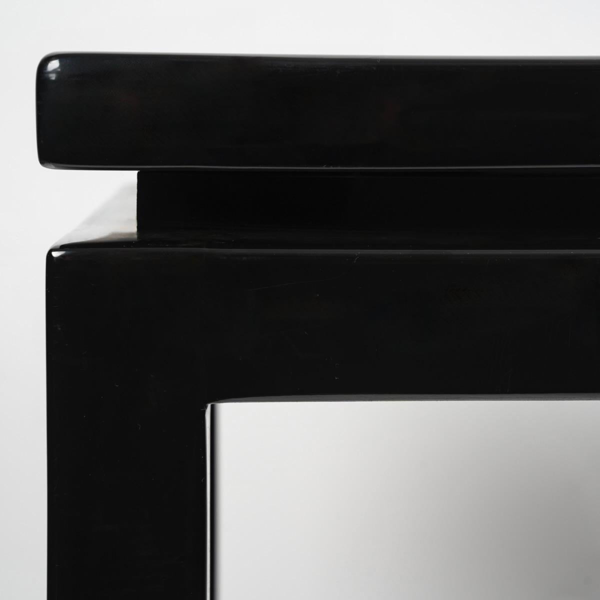 Large console table in black lacquer.
Composed of a long rectangular top resting on a recessed rectangle on which are positioned 4 high rectangular section legs positioned at the four corners of the console.
Details on the bottom of the legs and the