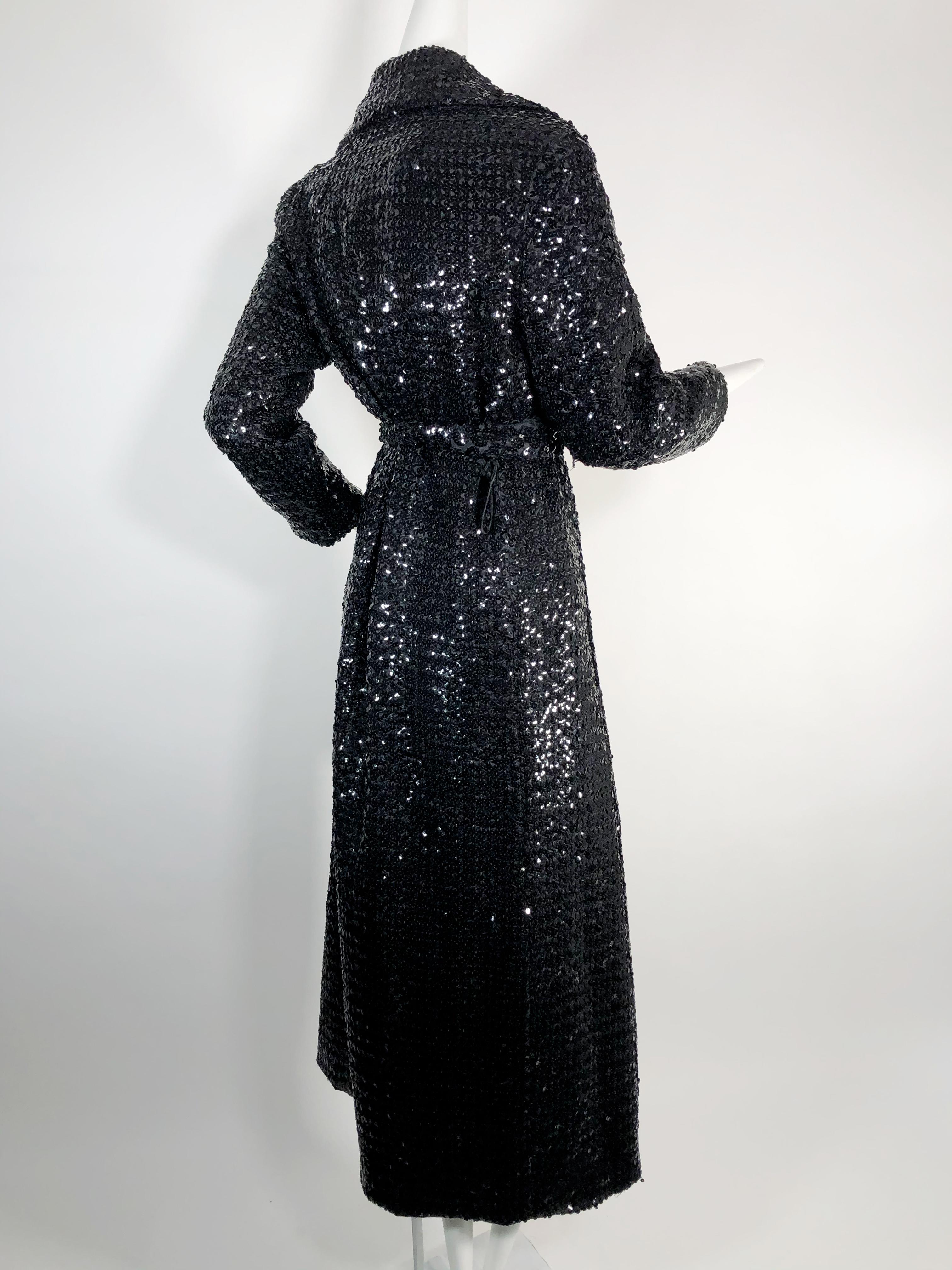 Wrapping this fabulous 1970s black sequin maxi-length trench coat around oneself is heaven with its heavy satin lining and generous notched collar! Original belt included. Fits approximately a US size medium.
