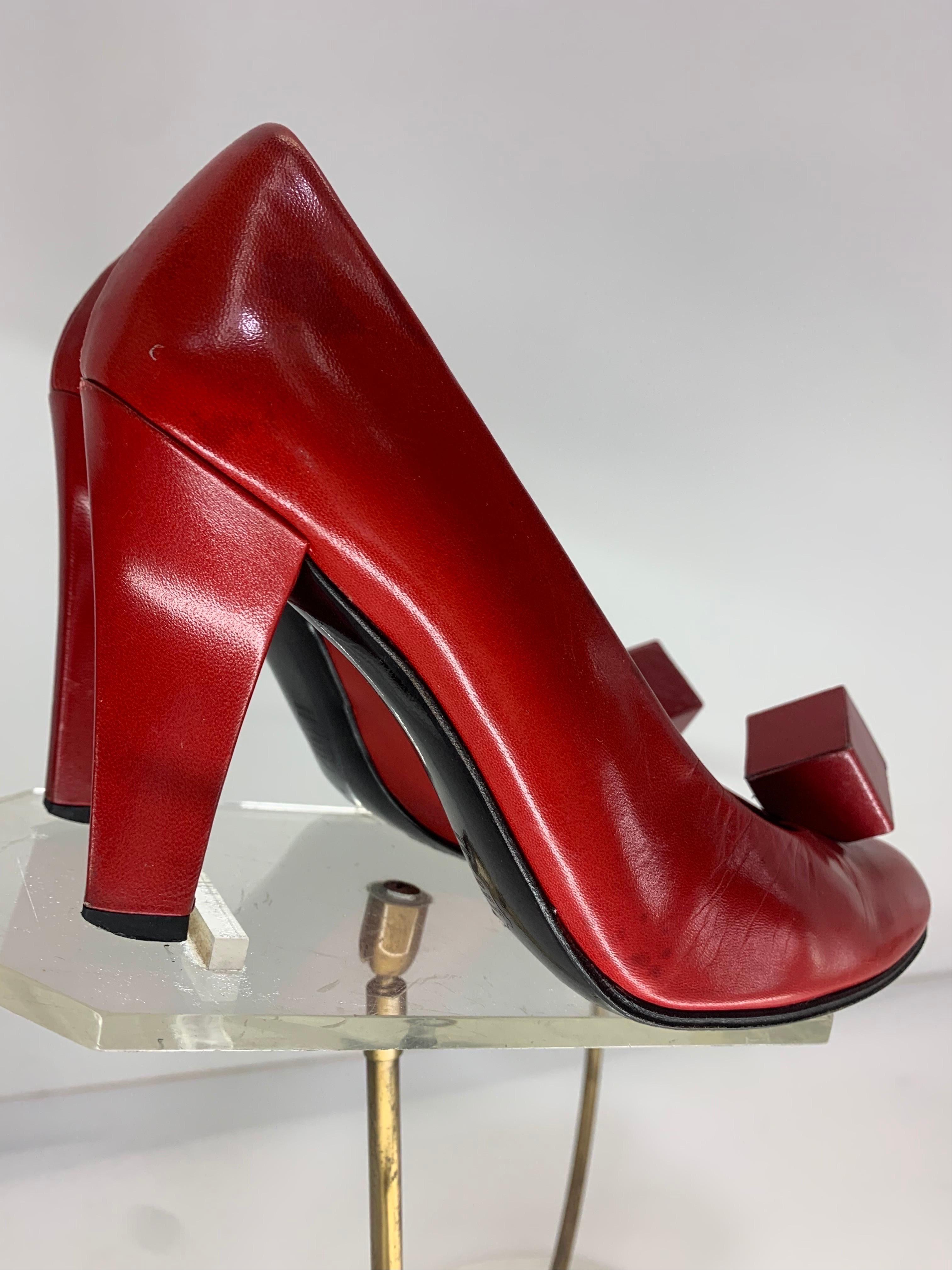 A fabulous 1970s pair of crimson red leather high heeled pumps by Charles Jourdan with a well-known signature cube ornament at toe!  Size 5 to 5.5