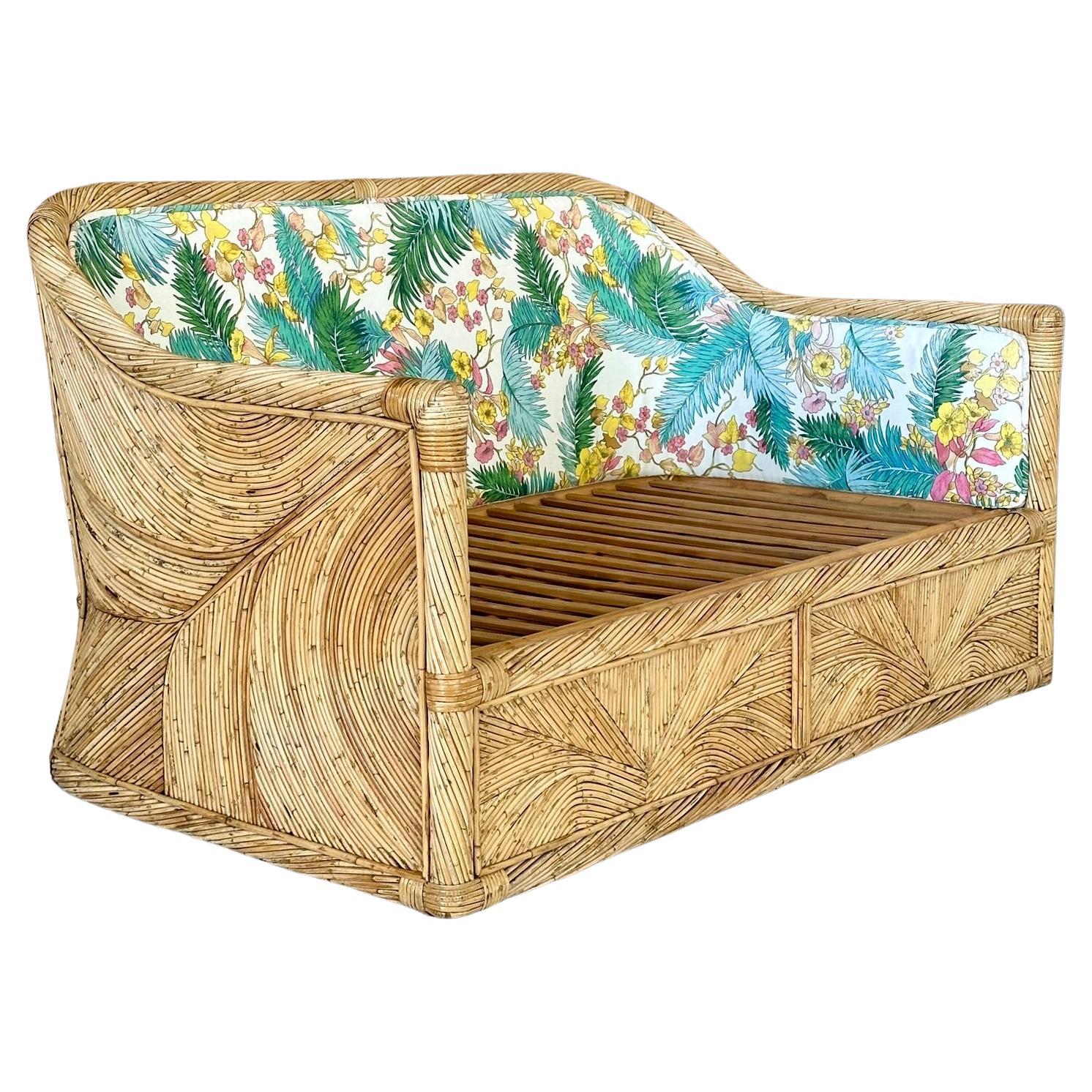 
Introducing an extraordinary vintage pencil reed rattan loveseat with original tropical upholstery, reminiscent of the style of Gabriella Crespi. The sides and back showcase a gorgeous reed rattan design, making this piece a true statement in any