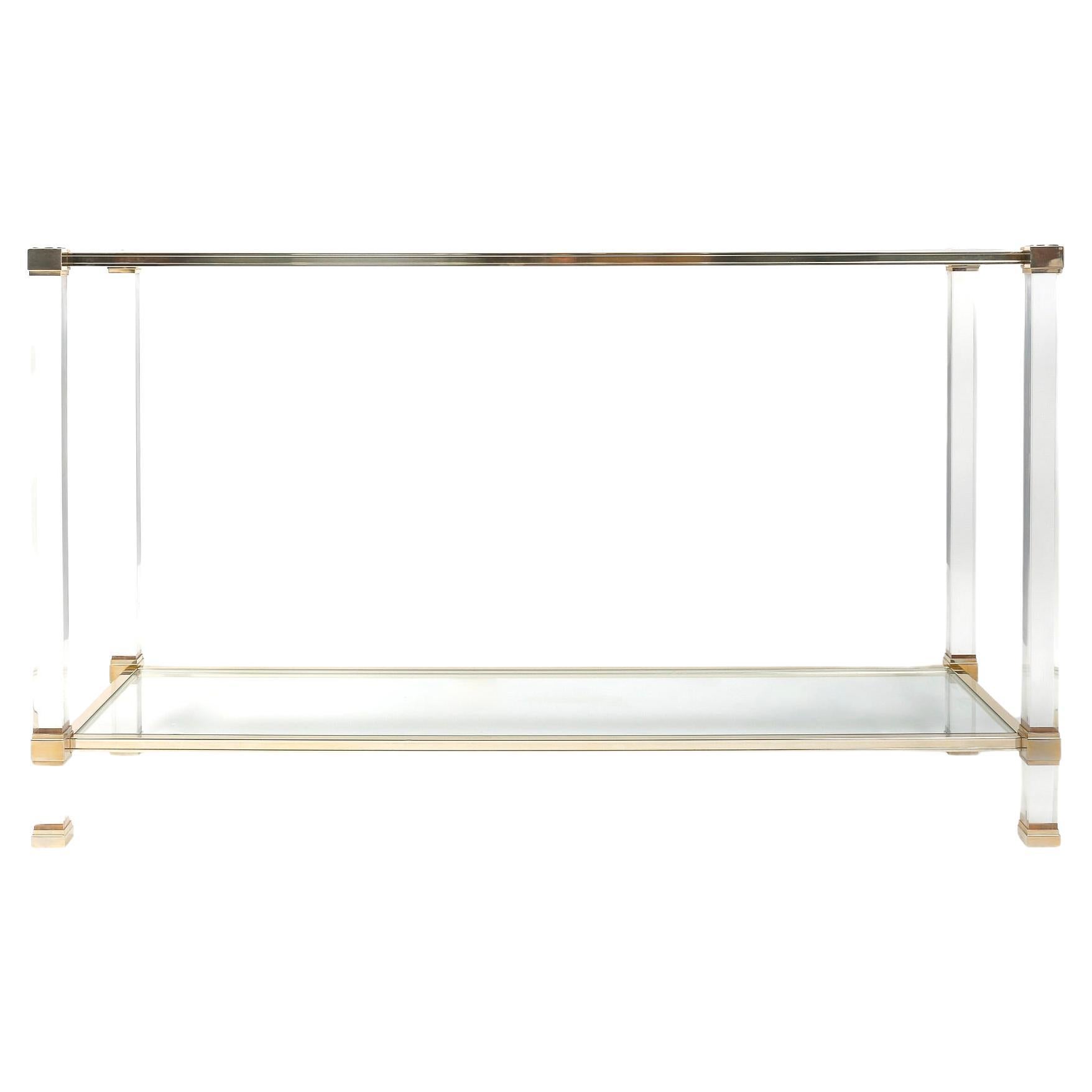 Rectangular console table in Lucite and 22-carat gold-plated aluminum, by Pierre Vandel, in the mid-century French modern style.
Rectangular in shape, it rests on 4 square Lucite legs on which rest two gold-plated aluminum frames positioned at the