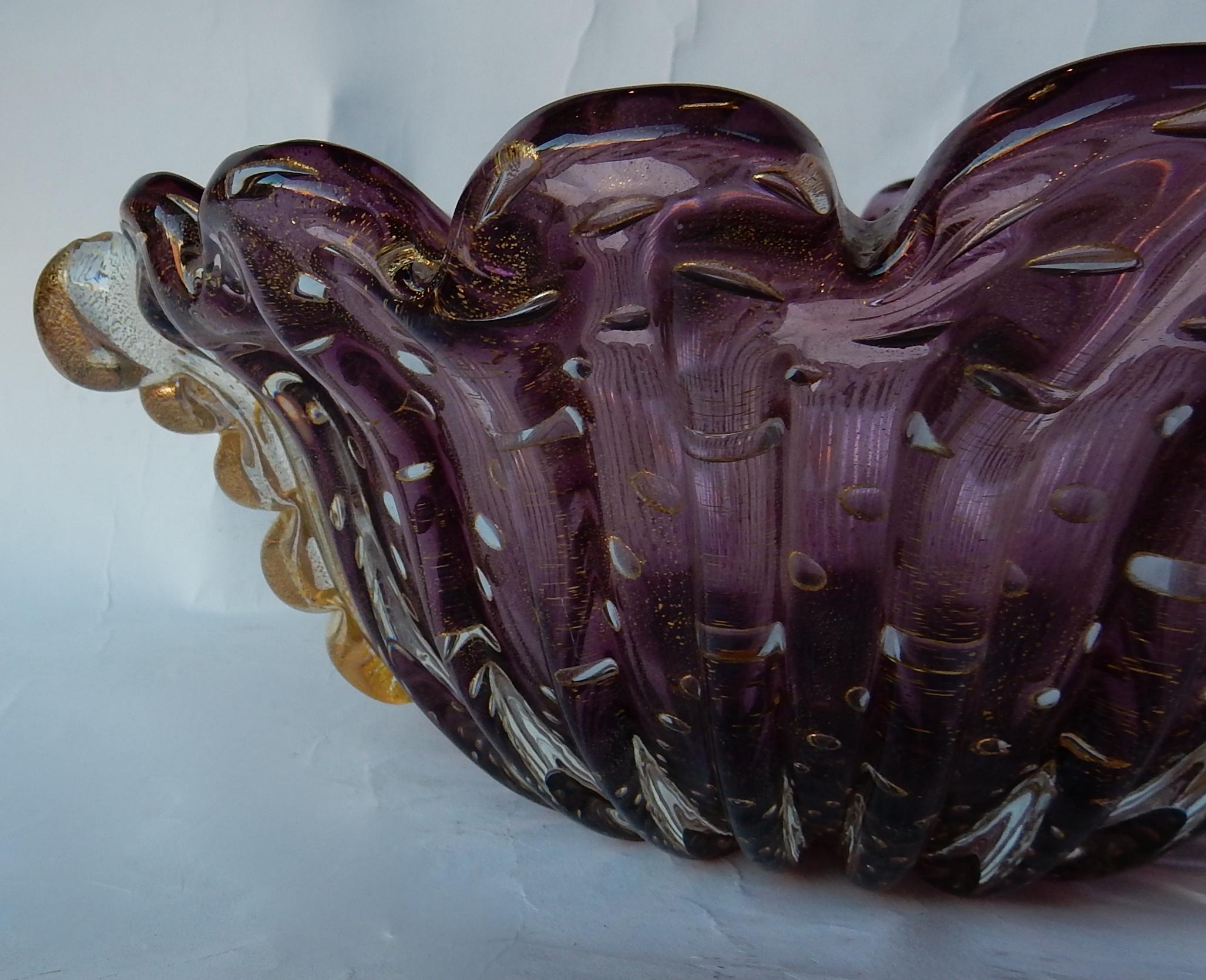 Cup of Murano with bubbles and gold inclusions, good condition, purple crystal and gold, signed Toso,
circa 1970

Measures: Length 34 cm
Width 32 cm
Height 14 cm.