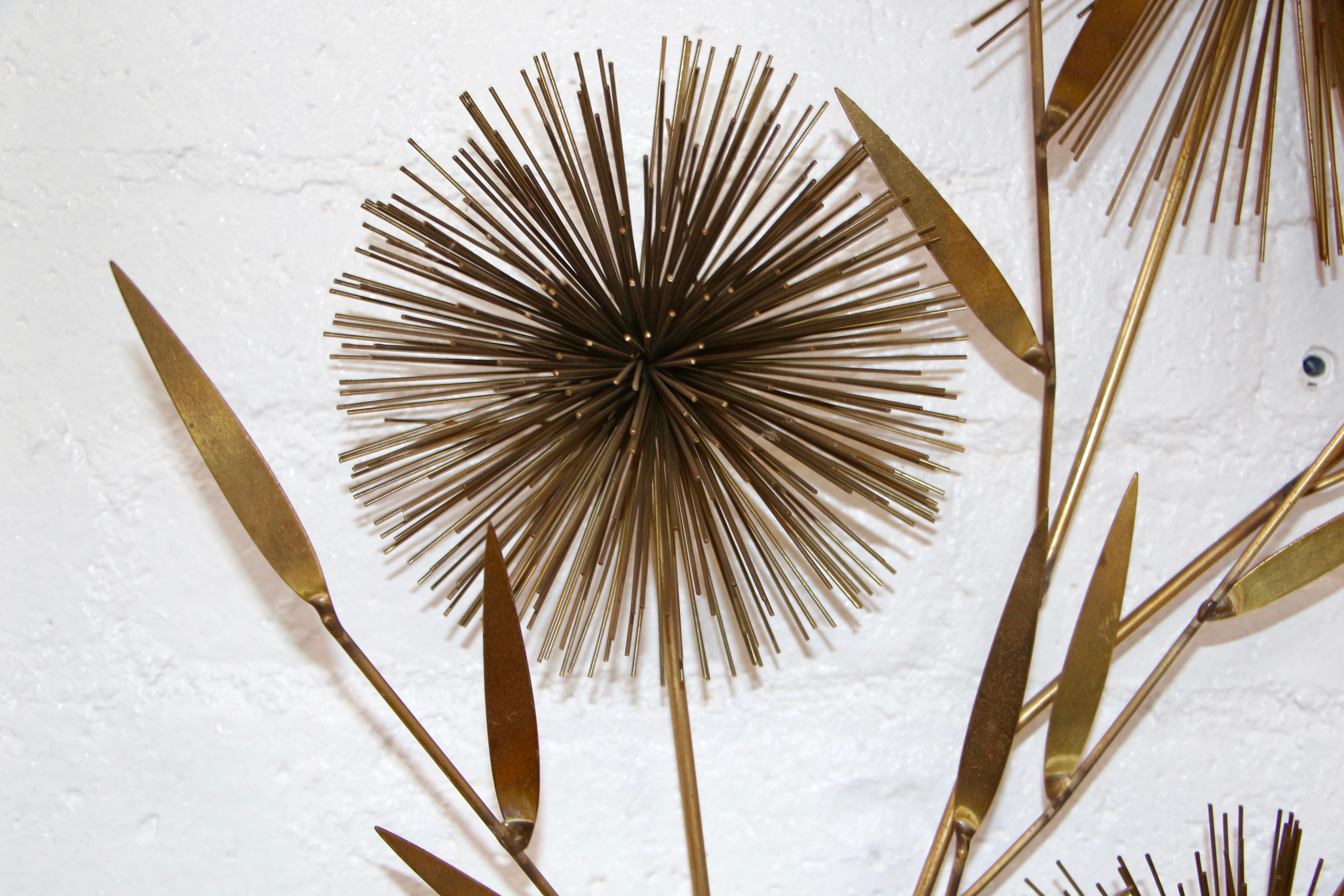 A signed Curtis Jere wall sculpture in the shape of a flower spray. They almost look like pom poms. Patinated metal with loses to the paint and patina. Signed and dated 1970.