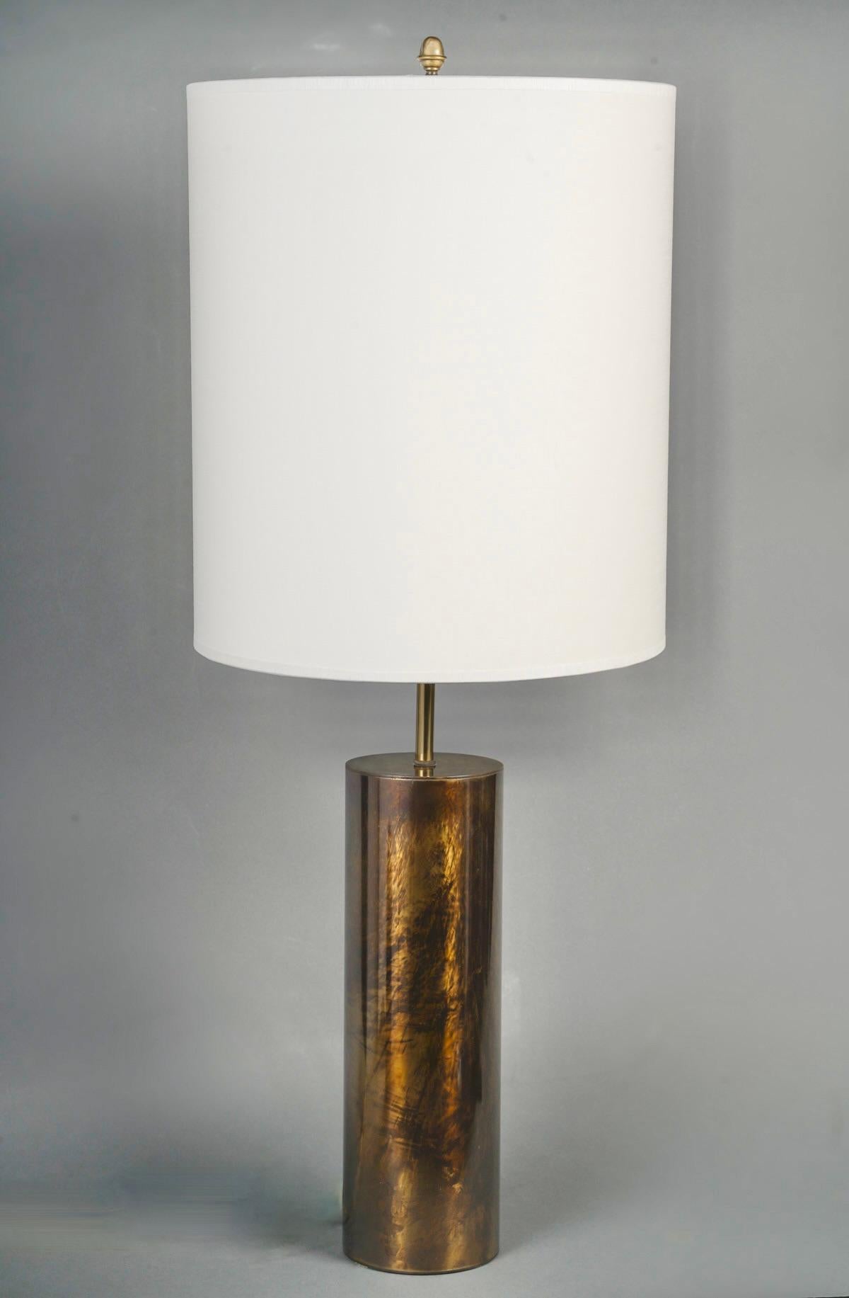 1970 Lampe en laiton églomisé par Maison Roche

Lampe de table de la Maison Honoré des années 1970.
Composé d'un socle en cylindre de laiton patiné brun et or, dit églomisé.
Il est habillé d'un abat-jour cylindrique blanc cassé à la finition