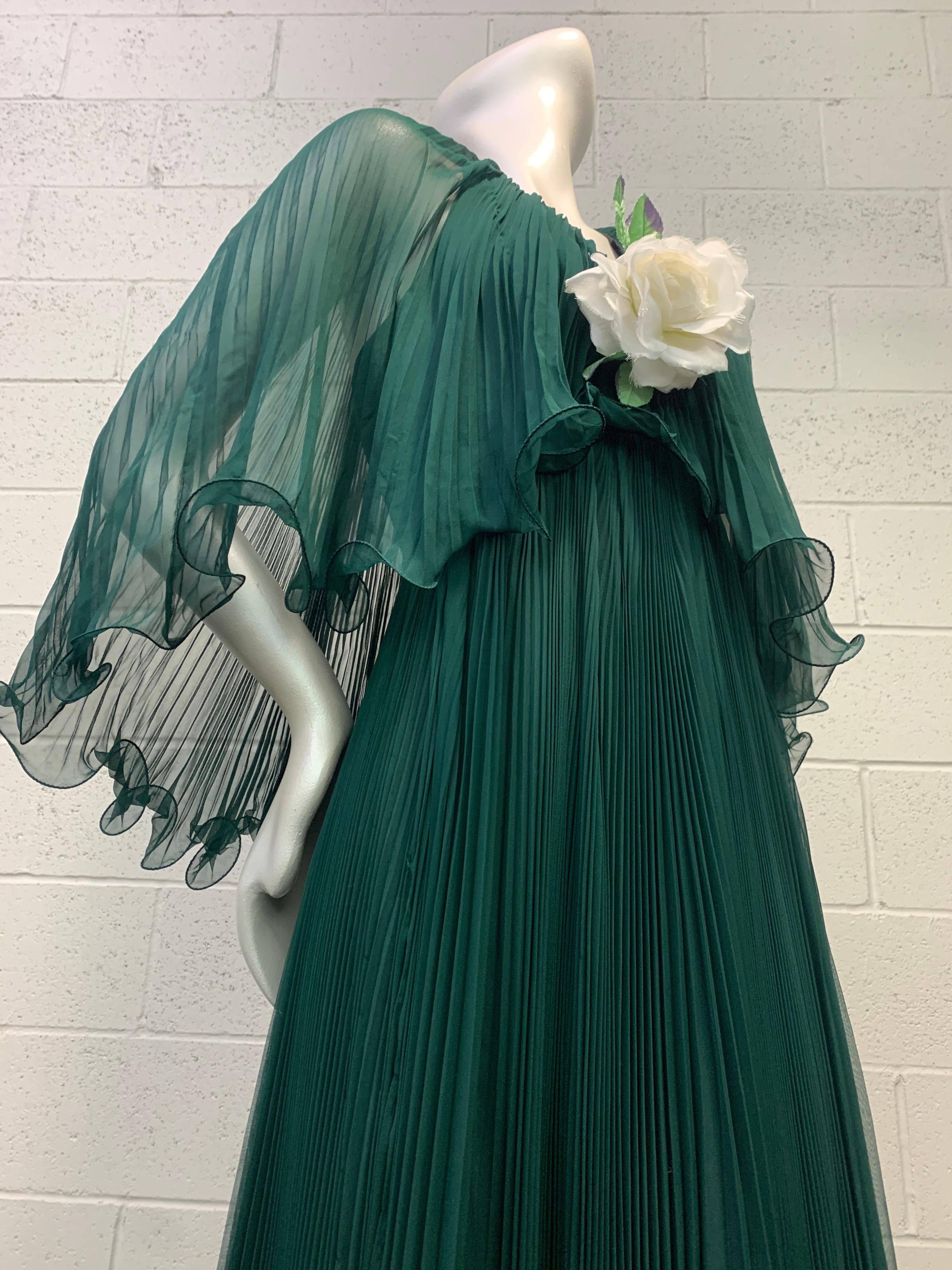 A lovely forest green 1970s pleated silk chiffon halter dress from Martha, the world-famous high end retailer. Voluminous accordion pleated chiffon overlay forms a caplet over this divine halter dress accented with a white silk rose at center bust.