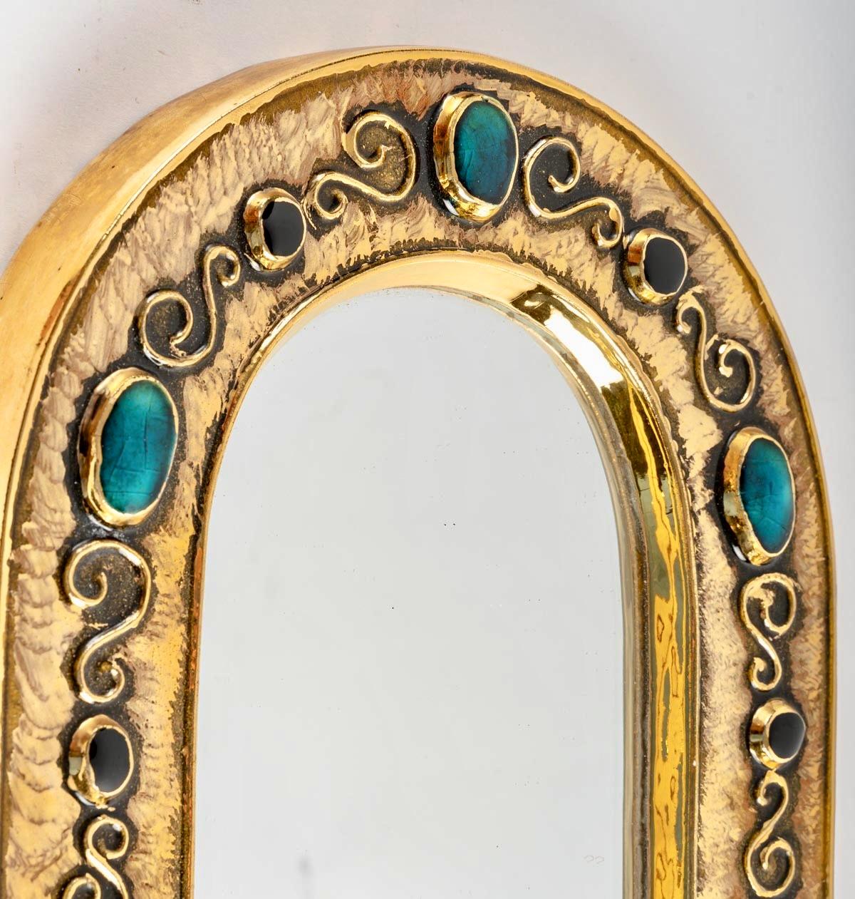 François Lembo miroir de forme romane, céramique, bijou, or, turquoise, noir. Miroir de taille moyenne, émaillé d'or et décoré de bijoux dans une alternance de motifs noirs et turquoise. Signé : F. Lembo au dos du miroir.

Originaire de Vallauris,