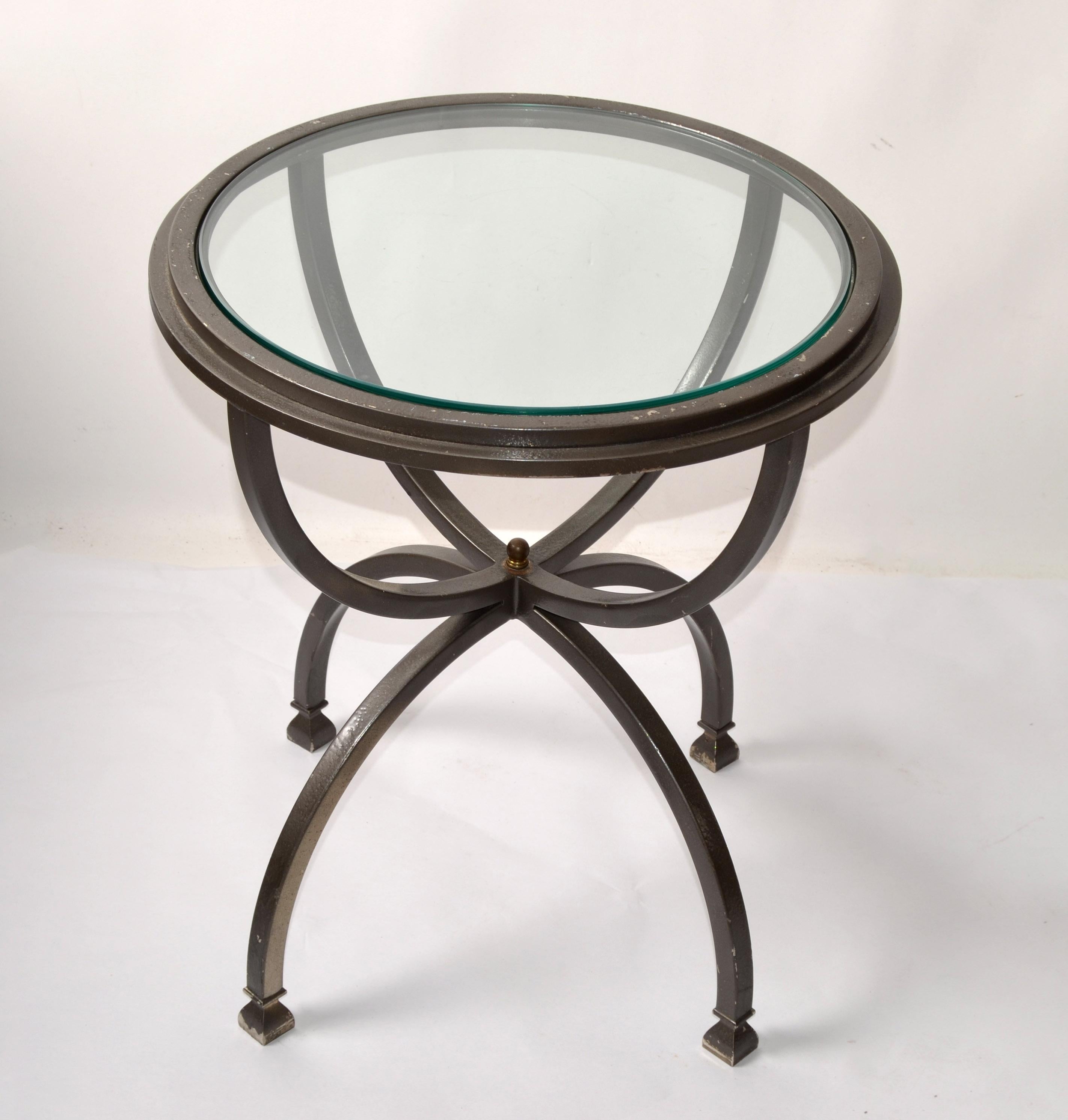 Mid-Century Modern French Maison Jansen Style Bend Steel Side, End or Drink Table with round Glass Top insert.
Brass Finial Decor at the Center where the sculptural Base and Top frame connects.
The dark silver-gray Finish has a distressed look and
