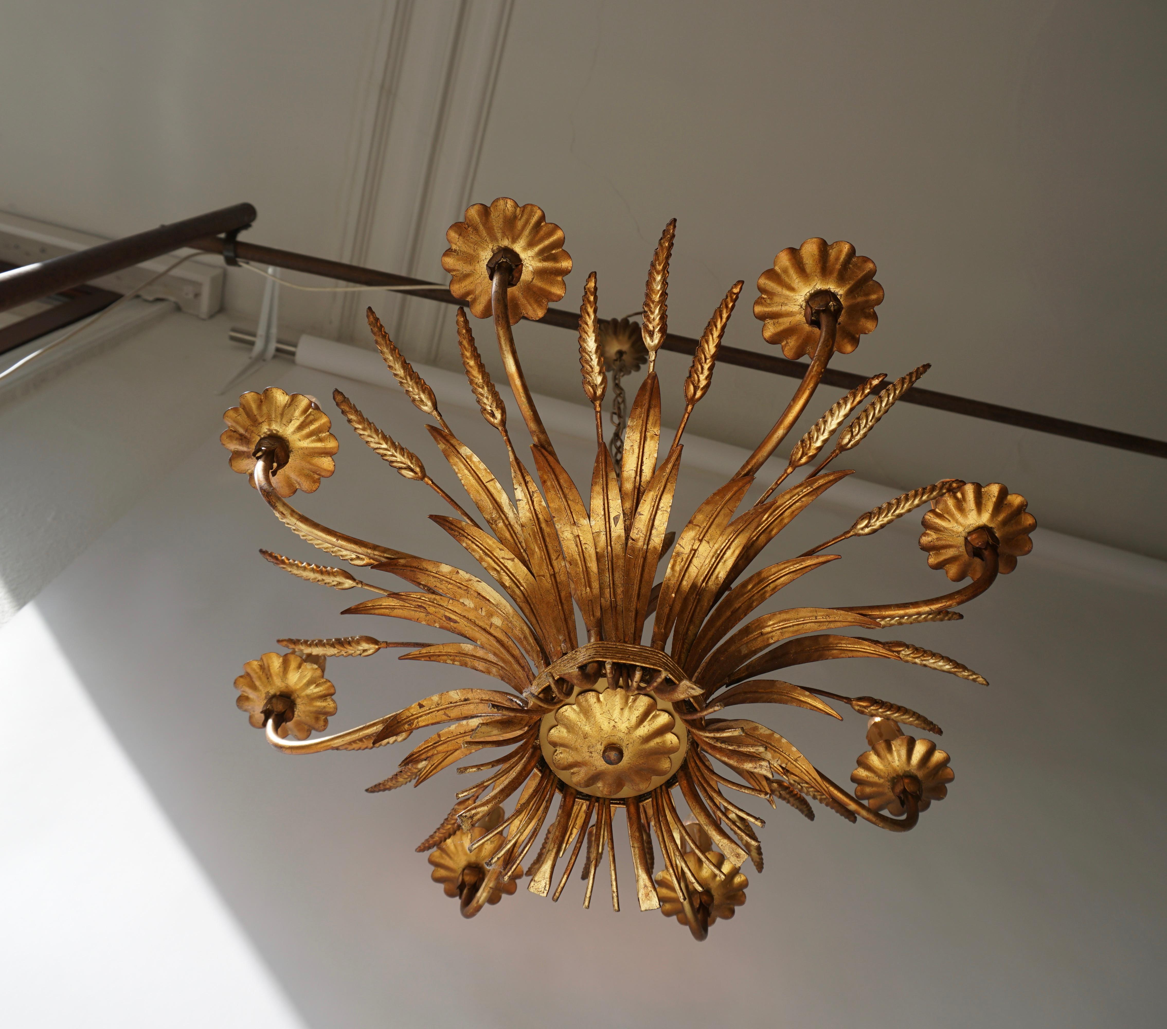 1970s gilt palm leaf chandelier.

The light requires eight single E14 screw fit lightbulbs (60Watt max.) LED compatible.
Measures: Diameter 67 cm.
Height fixture 45 cm.
Total height 110 cm.