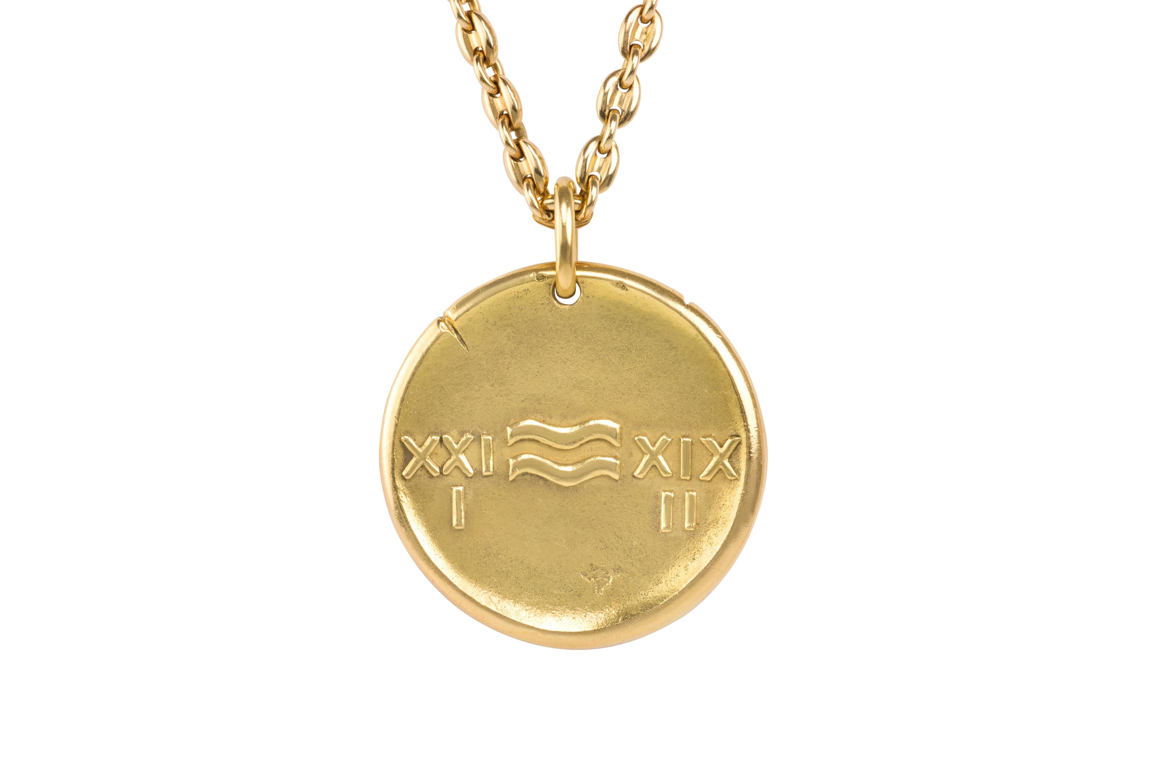 An 18 karat gold Aquarius zodiac pendant, by Georges Lenfant, c. 1970. 

The pendant is stamped with maker's mark for Georges Lenfant and French hallmarks. This pendant is identical to the version made by Van Cleef & Arpels in the 1970s, which was