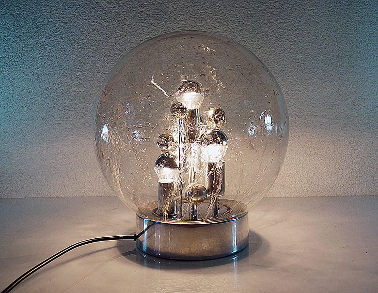 Elegant high quality Sputnik table lamp 'Big Ball' with a heavy, lava-like hand blown bubble glass ball on a chrome-plated base. Inside the lamp there are chrome spheres of different sizes, reminiscent of planet. Heavy design. 

A real design