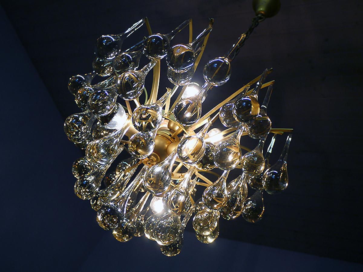 Elegante araña en forma de lágrima fabricada por Venini con gotas de cristal de Murano transparente montadas en un marco de latón dorado. 
 
La lámpara de araña ilumina maravillosamente y ofrece mucha luz. Un verdadero punto de atracción incluso sin