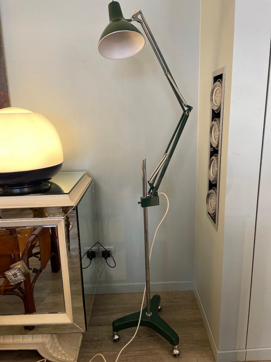 Lampadaire modèle Naska de 1970. La lampe est réglable en hauteur et orientable. Elle est fabriquée en métal émaillé et en aluminium. La lampe présente de petites traces d'usure, les roues coulissent bien, de même que le mouvement d'orientation de