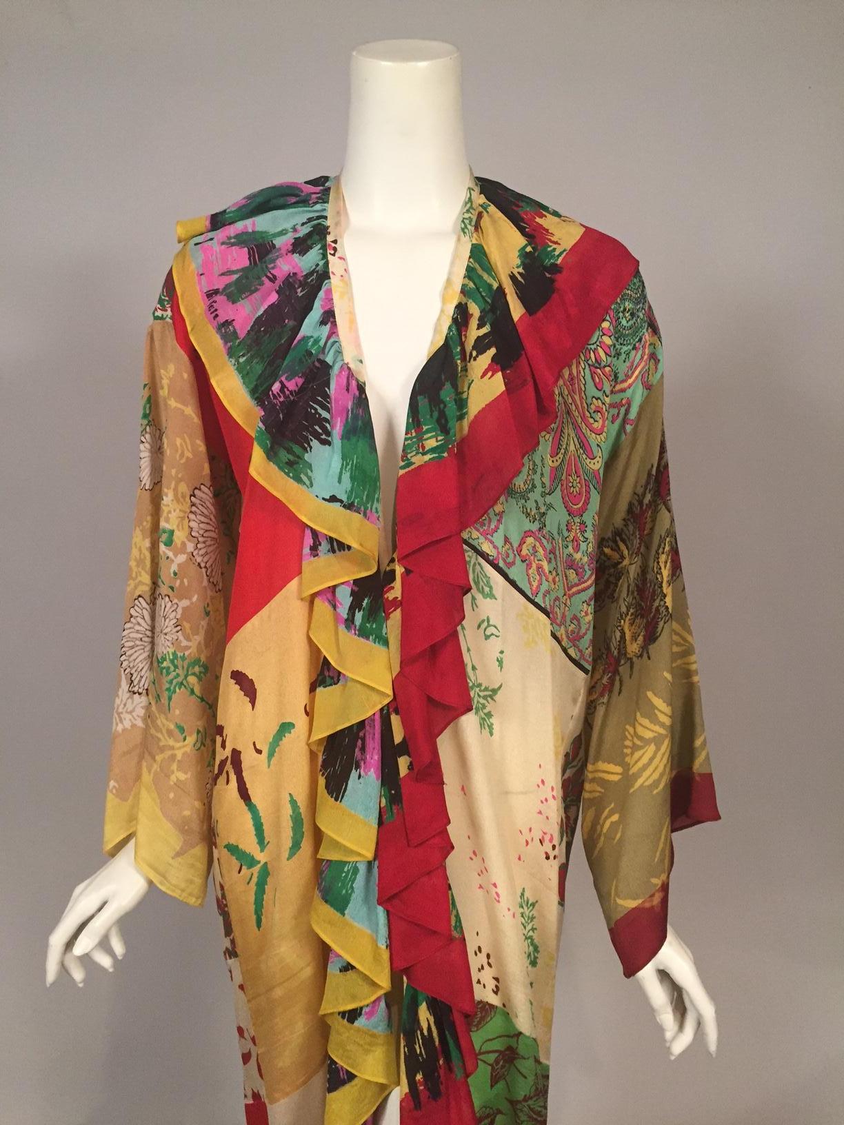This charming and colorful dress was made from an assortment of printed silk scarves and retailed by Henri Bendel circa 1970. It is an adaptation of then current street style for a rich Hippie look. The scarves are pieced together beautifully. The