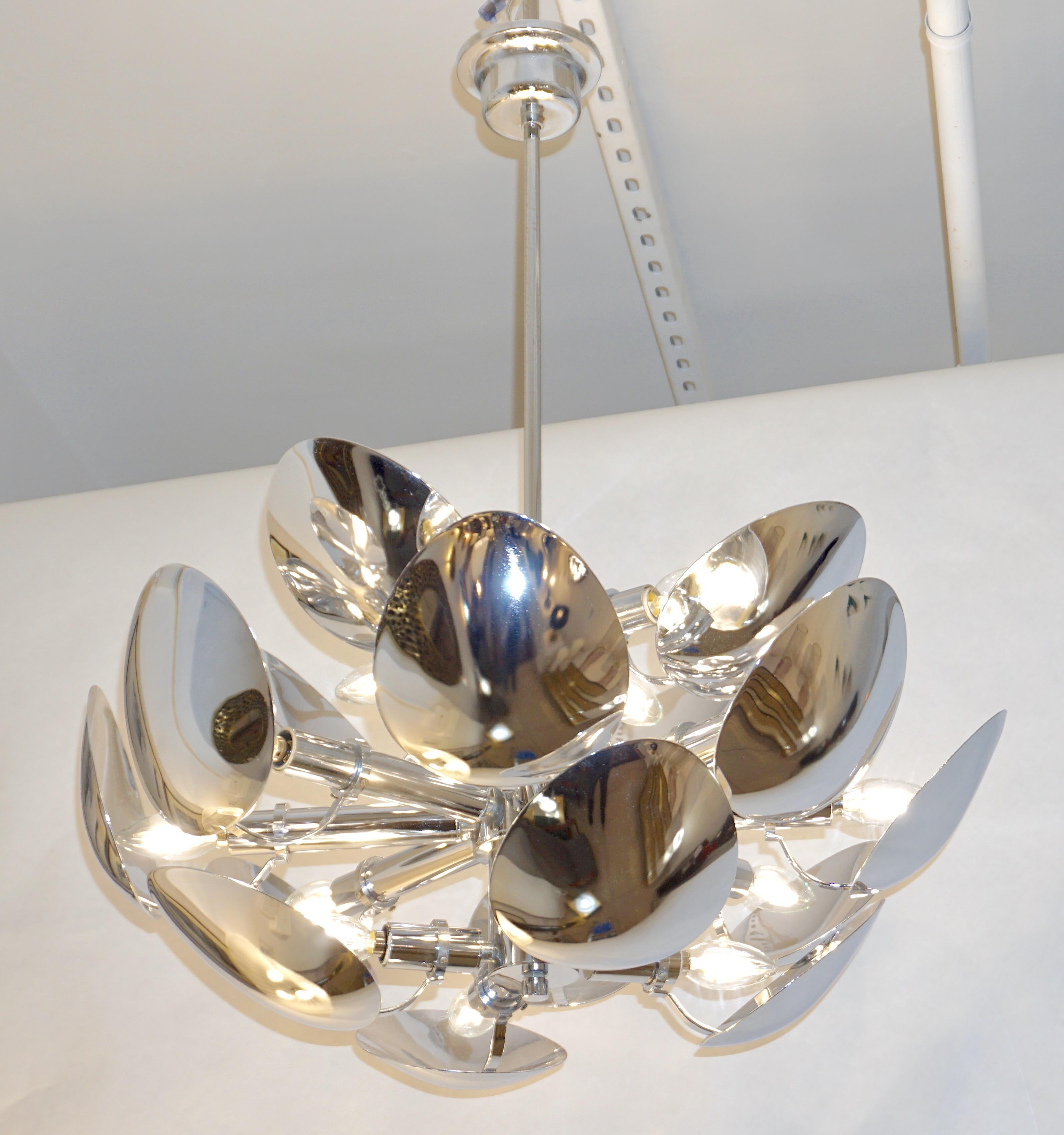 Mid-20th century Italian light fixture by Reggiani, composed of 16 overlapping concave silver chrome oval leaves that hide the light source and depart from a central pole. The construction and design produce very atmospheric ambient lighting. High