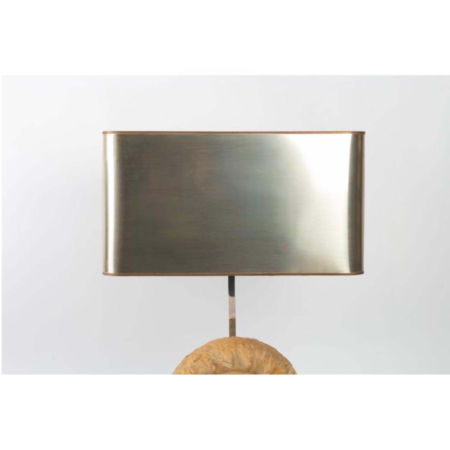 The base of the lamp of rectangular section is out of brushed silver plated steel on which is posed a beautiful fossilized ammonite.
A square section rod in silver plated metal passing at the back of the lamp on the base goes up to the top of the