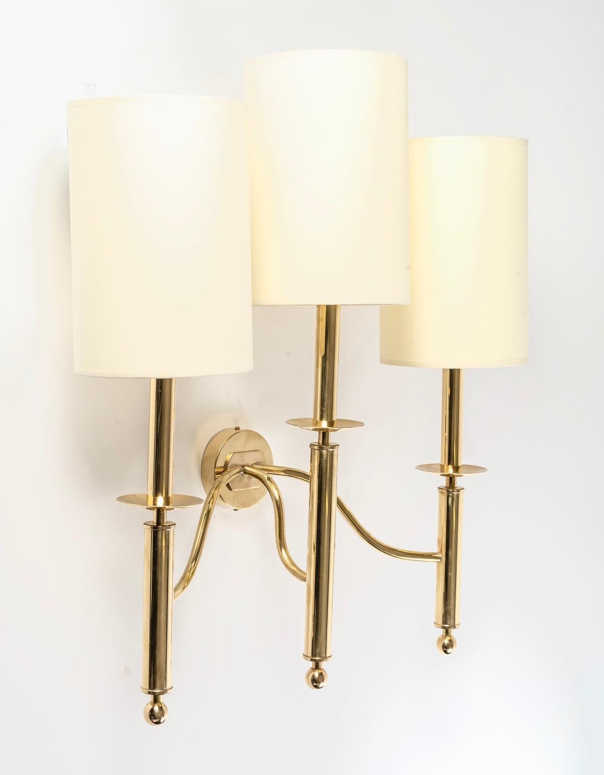 Elegant pair of wall lights, made up of 3 arms formed by 3 long tubes of round section underlined by small cups placed high on the upper part and dressed in cylindrical-shaped shade in ecru cotton made to measure.
On the lower part of the small
