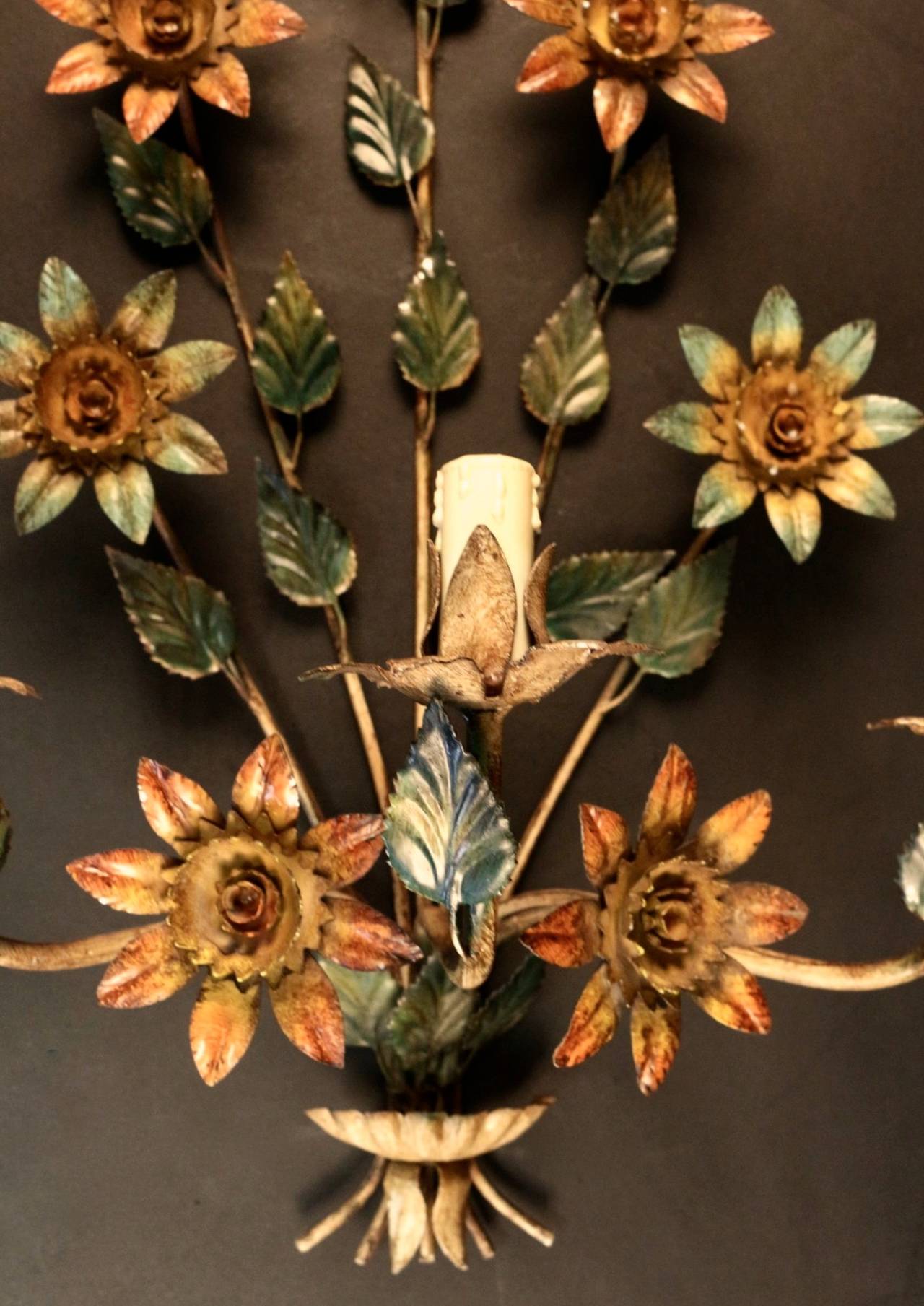 Large bouquet composed of stylized sunflowers, 7 flowers per sconce and foliage. 
Composed of 5 floral stems of different heights, three arms of light distributed on each side of the sconce and one on the front face.
They are dressed with candles